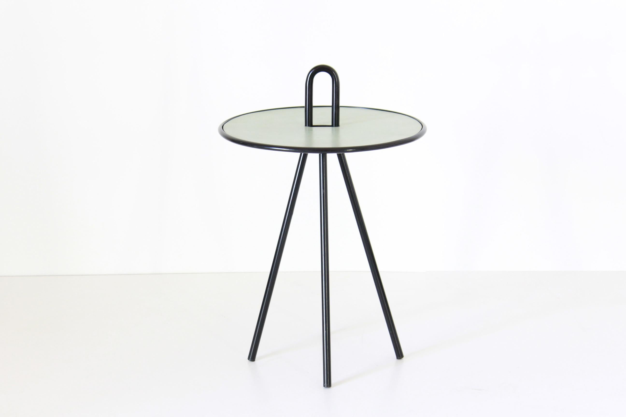 A 1960s vintage side table with curved black iron structure and plastic round top. In very good conditions with only few signs of time. 

Top Height. 50 cm.