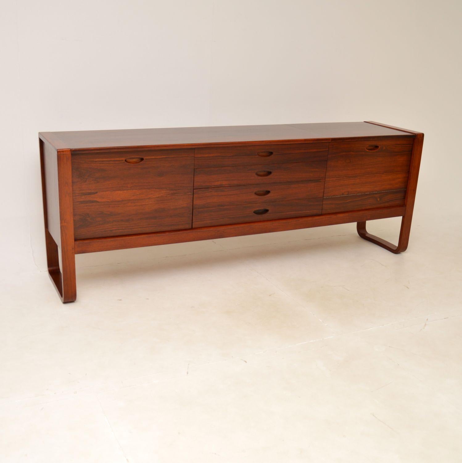 An absolutely superb vintage sideboard. This was made in England, it was designed by Gunther Hoffstead for Uniflex, it dates from the 1960’s.

The design is stunning, this is extremely well made with many fine features. The U shaped sides are
