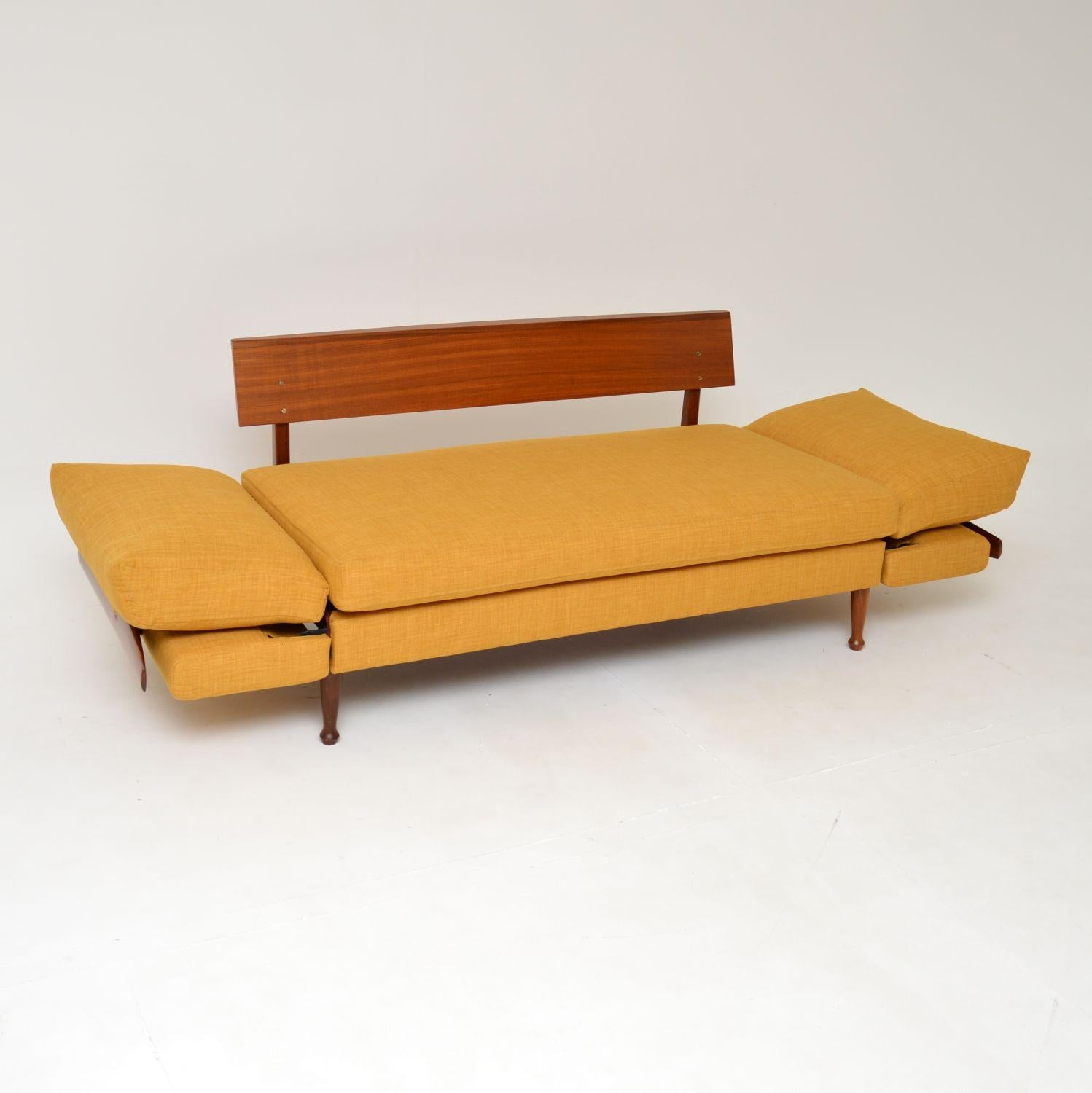 A superb vintage sofa bed in afromosia wood. This was made by Greaves & Thomas in England, it dates from the 1960’s.

The quality is fantastic, this is a very useful and compact size. The armrests drop down on either side and the back cushions go