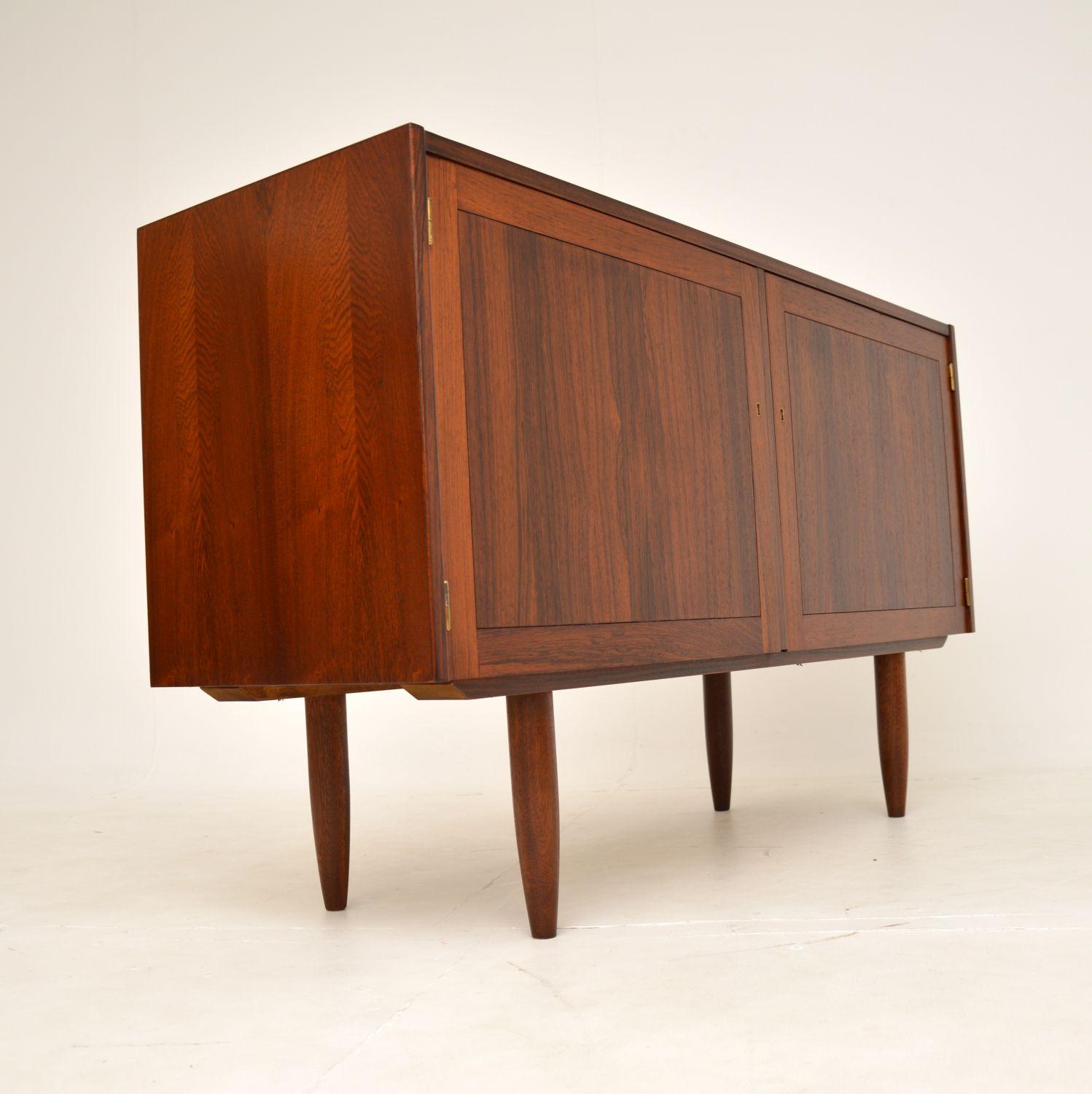 A very stylish and well made vintage wooden sideboard. This was made in Sweden, it was designed by Nils Jonsson and made by Troeds.

It is of lovely quality, with beautiful grain patterns and a gorgeous colour tone. The interior is lined with