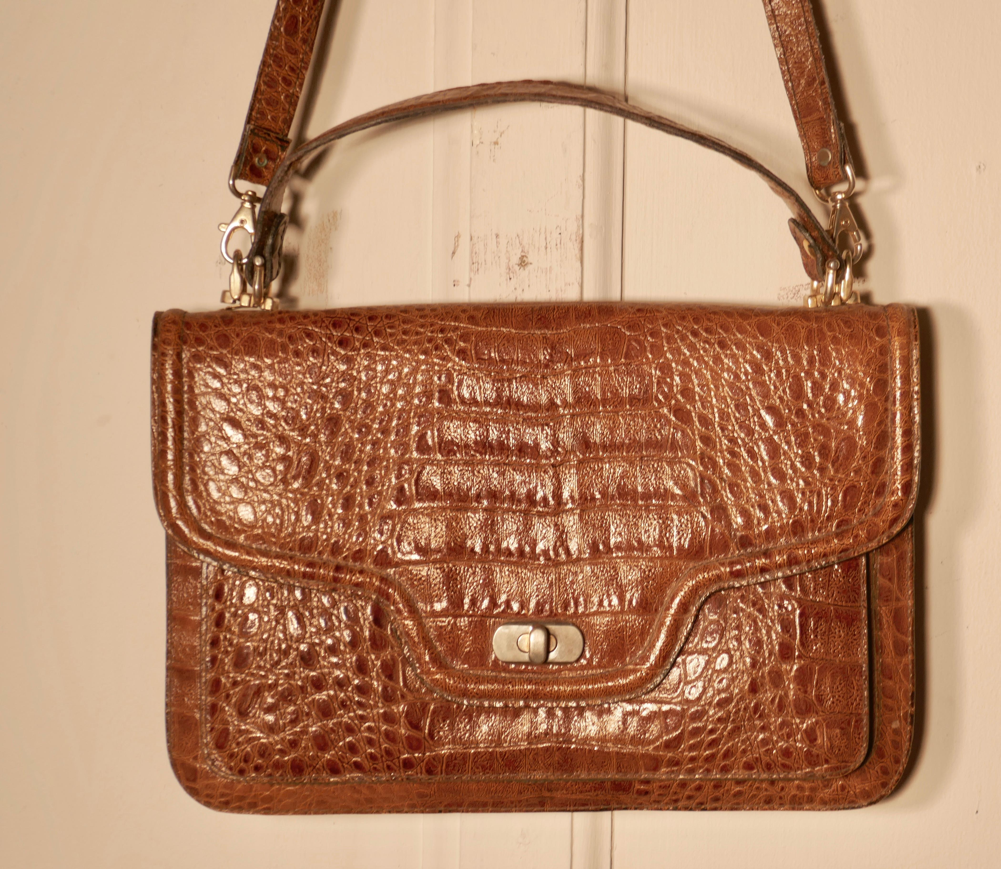 1960s Vintage Tan Crocodile Hand/Shoulder Bag

A great Vintage piece in very good clean condition, the bag has a choice of a single hand carrying handle and the addition of an over shoulder clip in handle turns it into a cross body bag
The interior