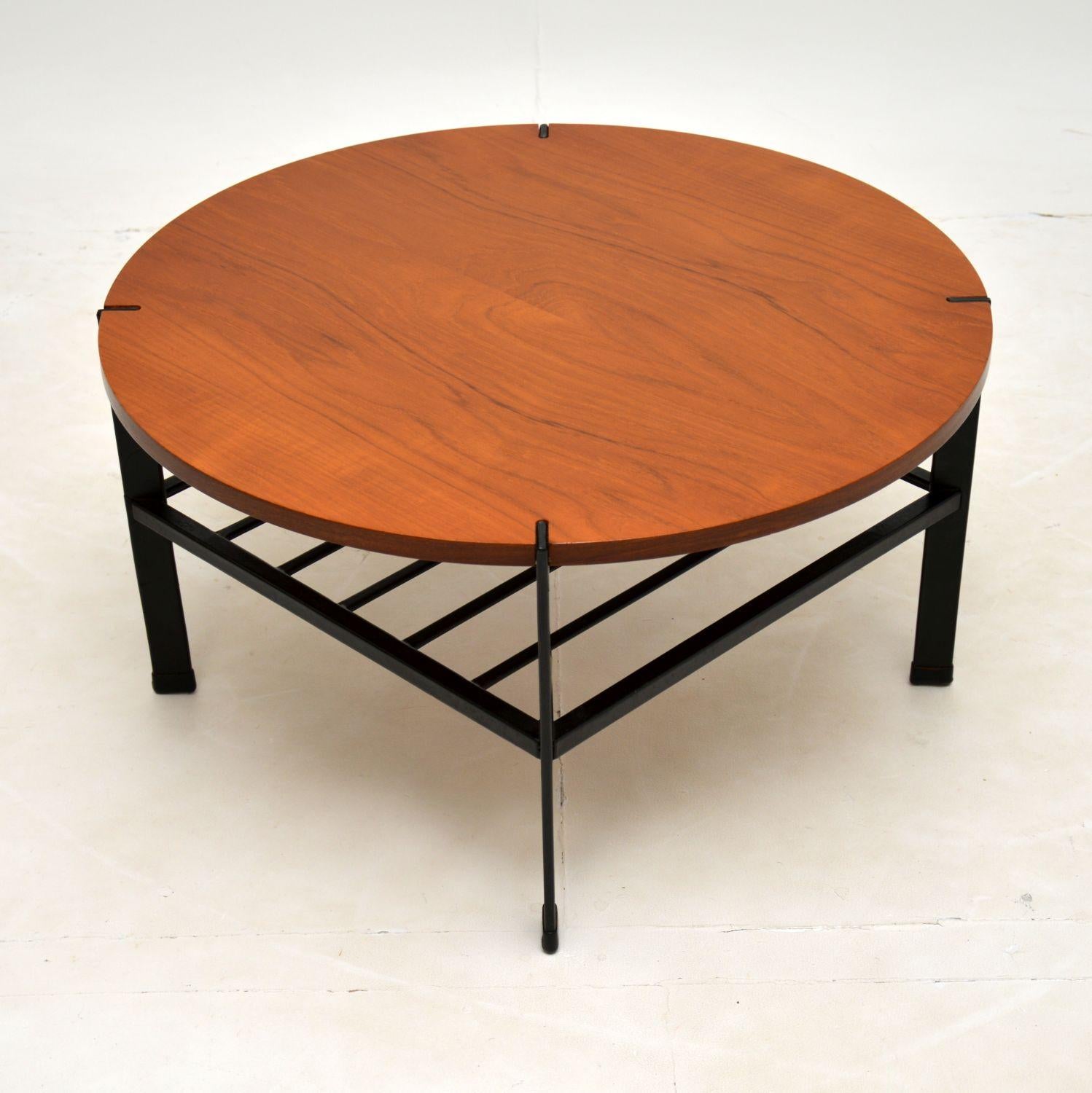 A lovely vintage coffee table in teak, with an ebonised steel base. This was made in England, it dates from the 1960-70’s.

The design is excellent, this has a circular teak top which is supported in an interesting way, the flat metal legs