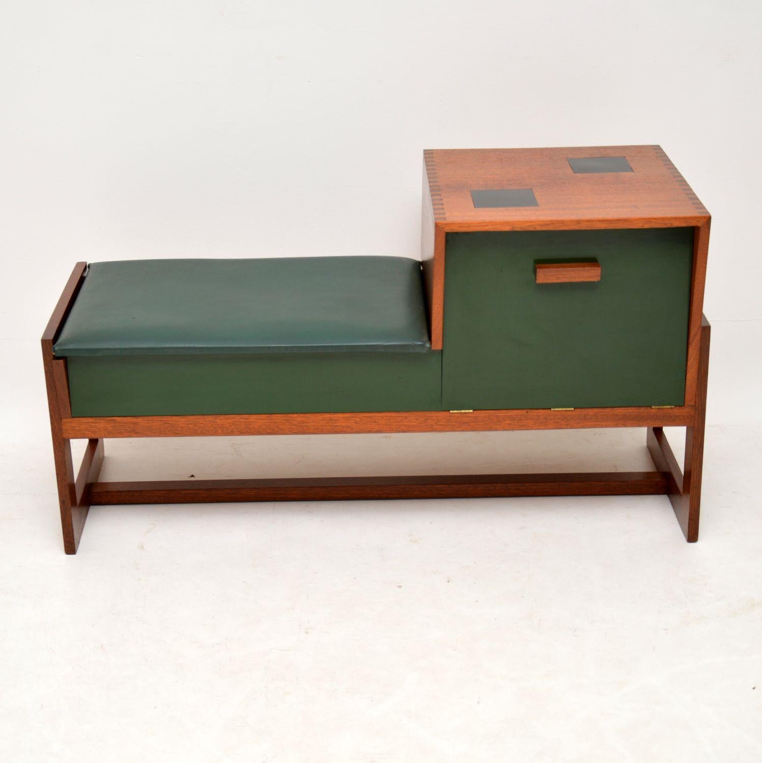 This is the most interesting telephone table / entry bench we’ve come across, it dates from the 1960s. It’s made from teak, with a green Formica front and green vinyl seat cushion. It has a good amount of storage space, the seat lifts up to reveal a