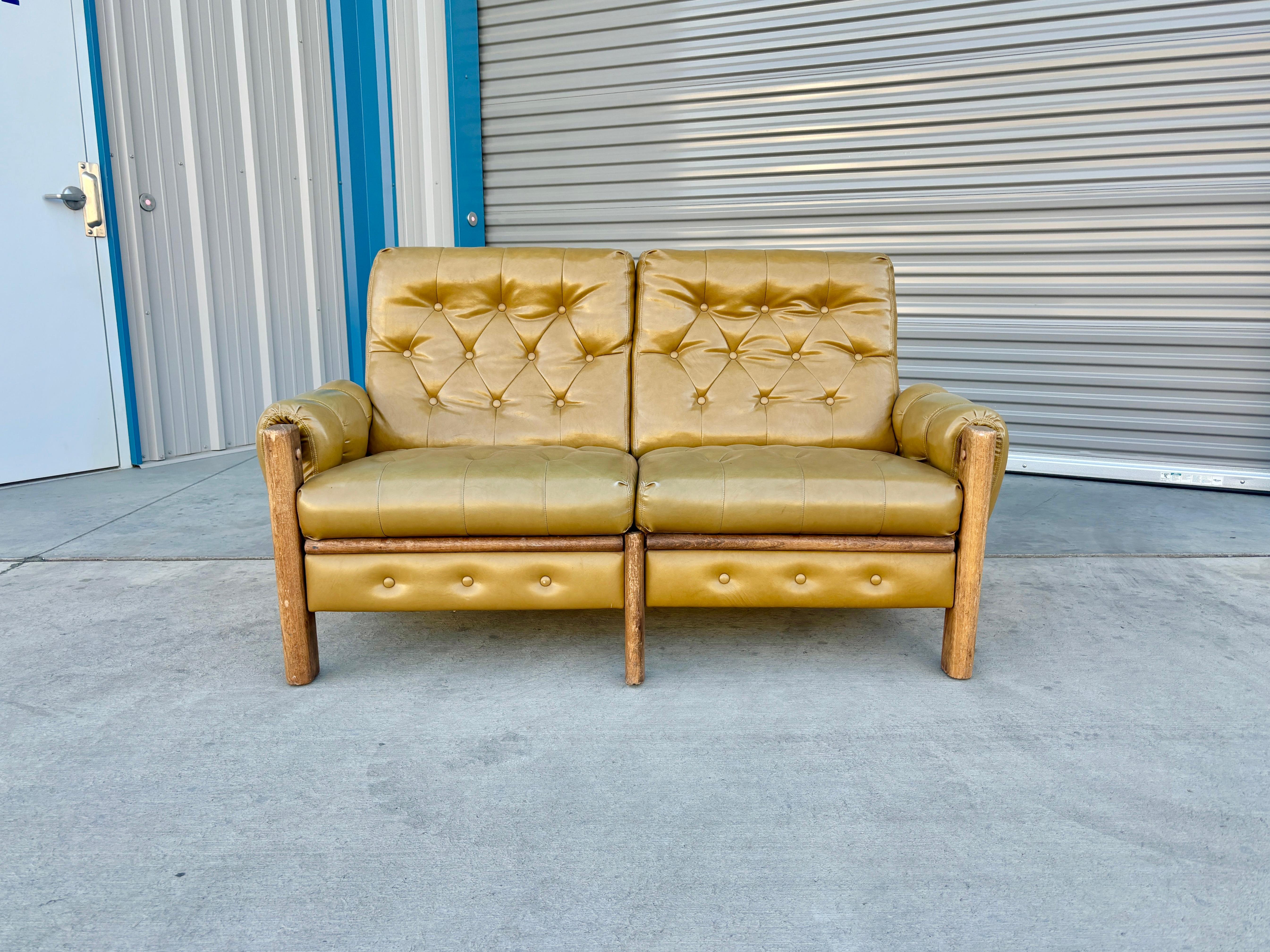 Welcome to Mid-Century NoHo

[Vintage Tufted Vinyl & Oak Loveseat]

This stunning vintage vinyl safari loveseat is an actual standout piece. The tufted mustard vinyl upholstery exudes warmth and character, perfectly complementing the sturdy oak