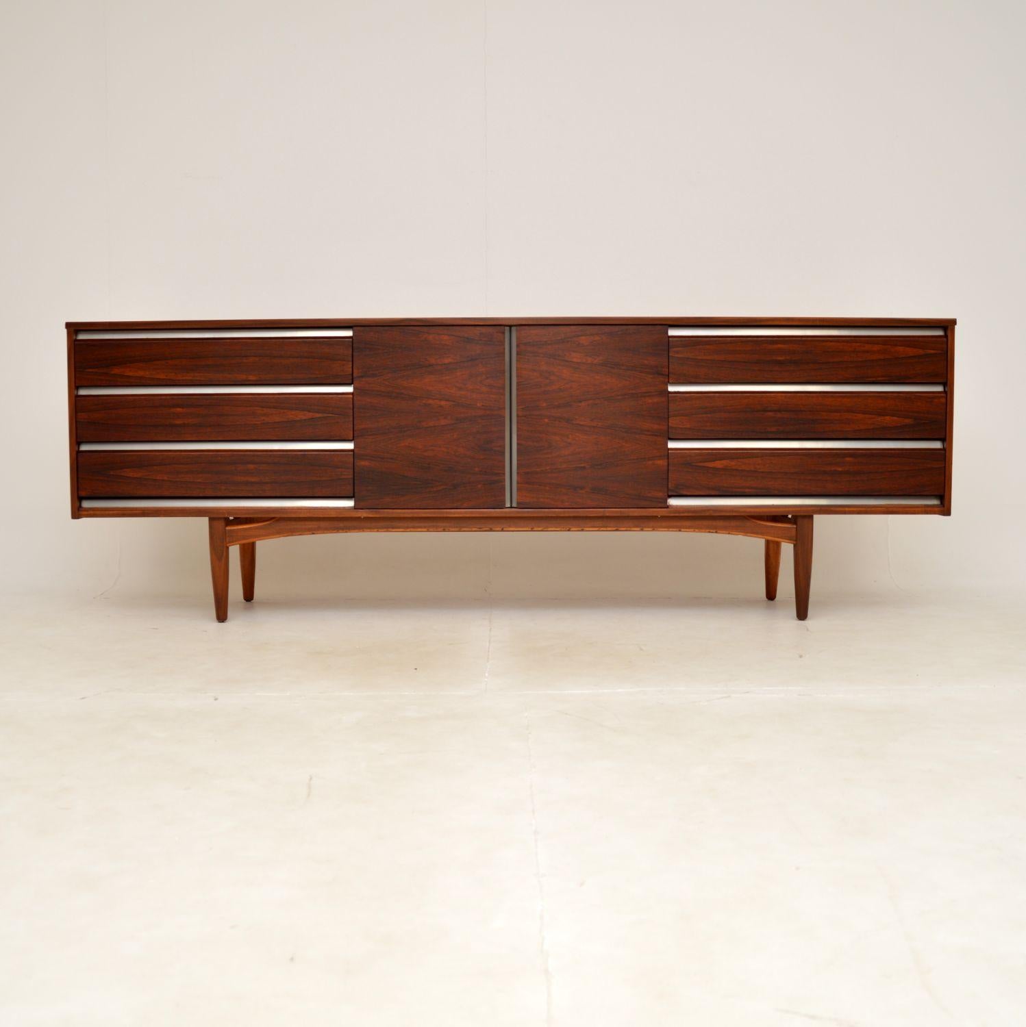 A very stylish and impressive vintage sideboard, walnut and chrome. This was made in England, it dates from the 1960’s.

It is of superb quality, it has an absolutely gorgeous front with stunning grain patterns. The top and sides are walnut, the