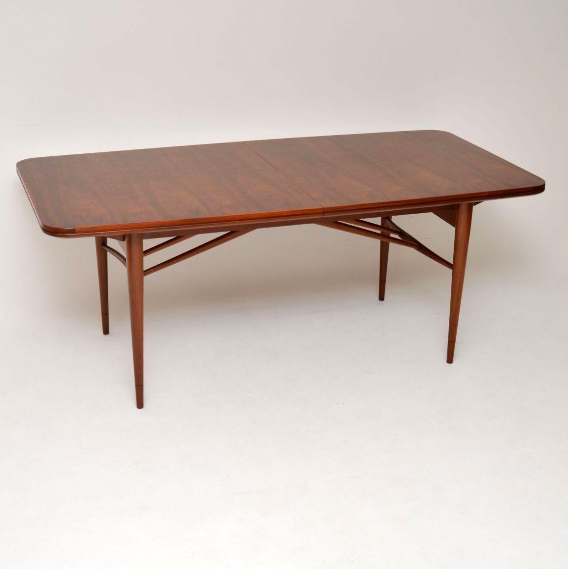 A beautiful and very rare dining table in walnut, this was designed by Robert Heritage and made by Archie Shine in the 1960s. It has a fantastic design, with two extra leaves to extend the dining surface. The leaves can be stored beneath the