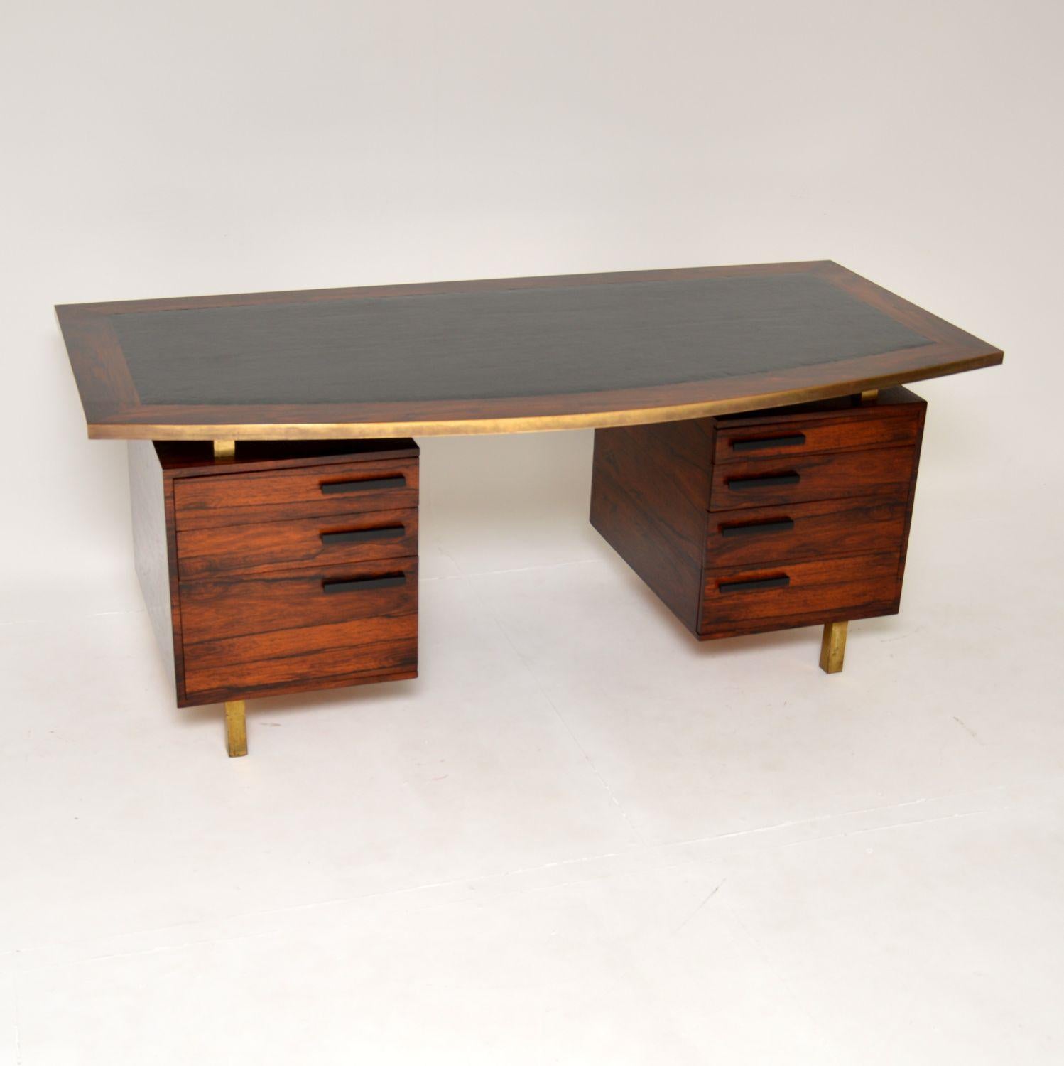 An absolutely magnificent executive desk of the highest order. This was made in England, it dates from the 1960’s.

This is very large and impressive, with an amazing and quite unusual design. The top has a bow shaped front, and a very high