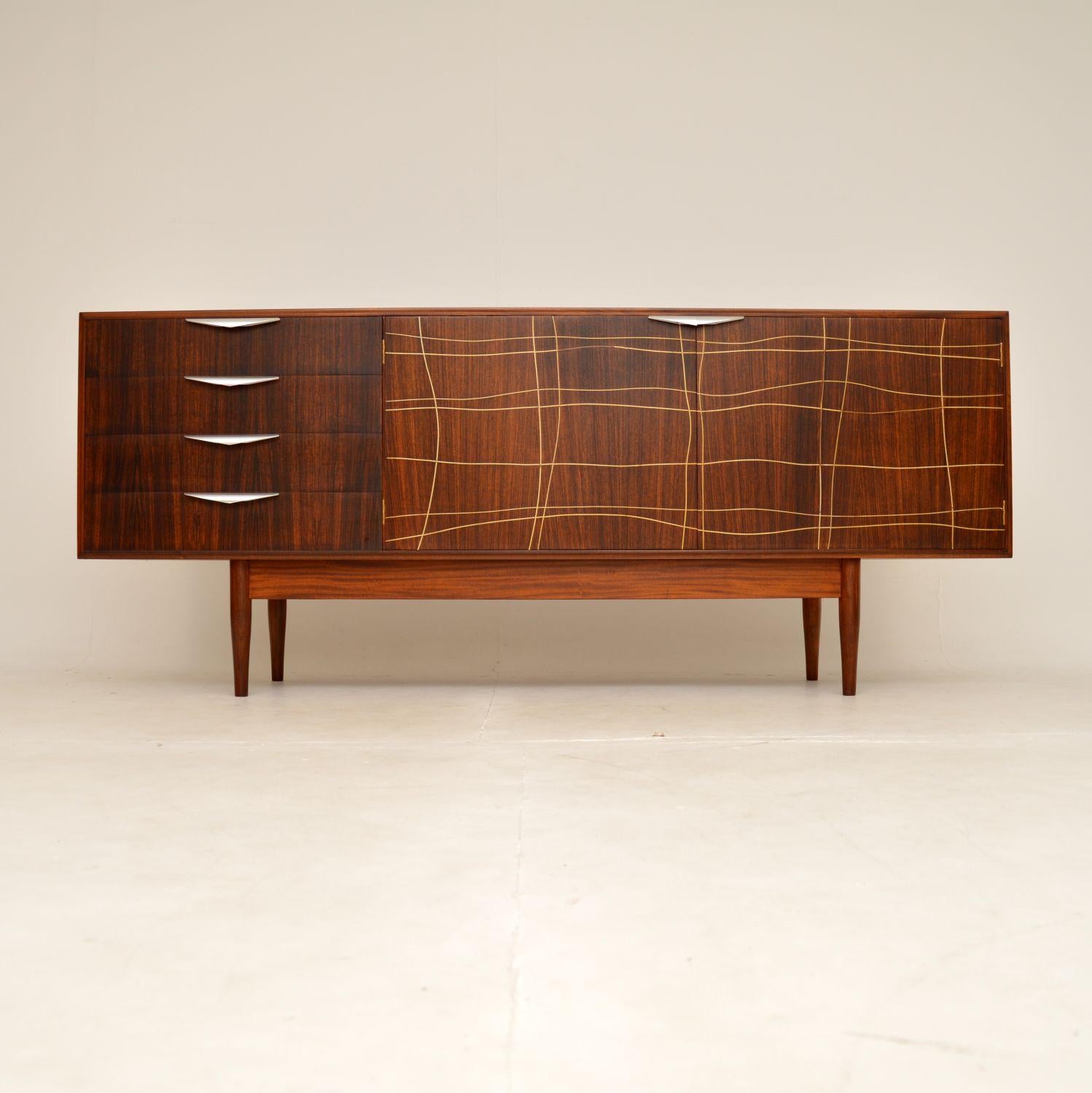 A very rare, impressive and stylish vintage sideboard. This was made in England by Dalescraft, it dates from the 1960’s.

It has an interesting and unusual design, with inlaid brass patterns on the two door fronts. The handles are brushed steel,