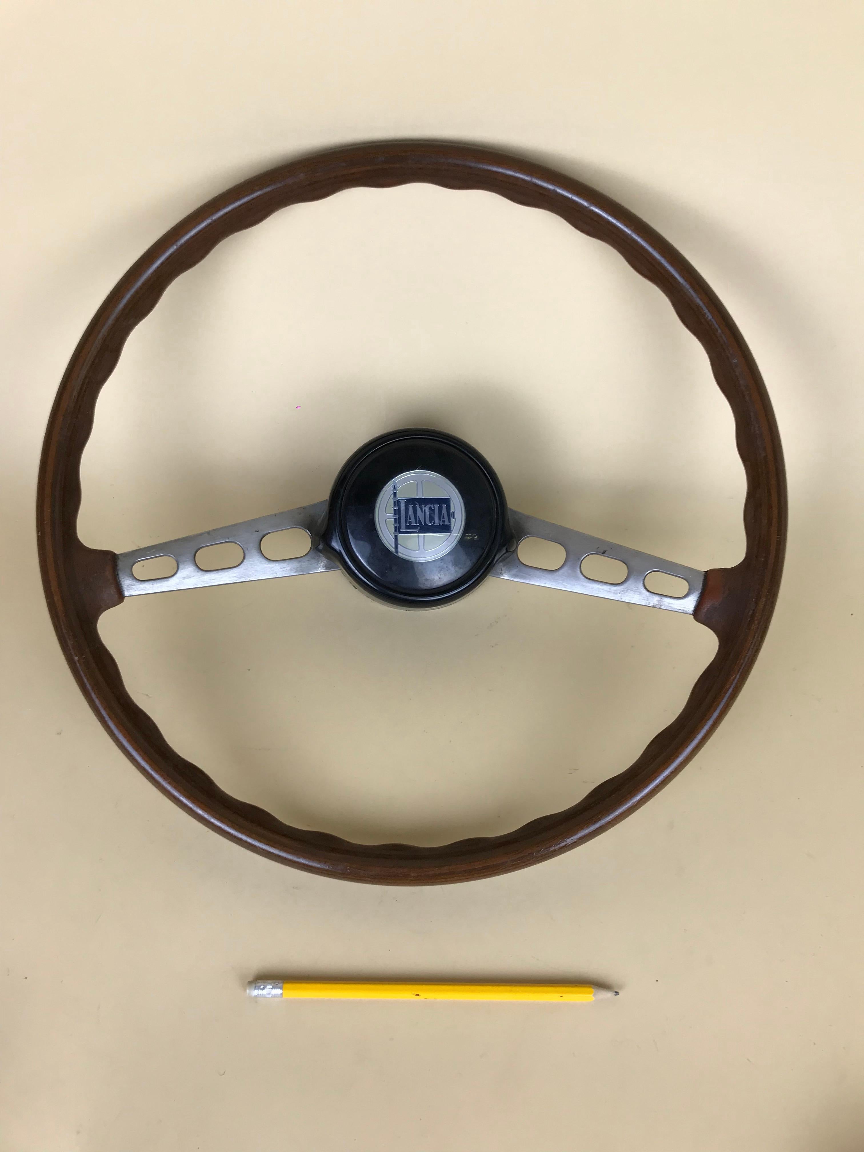 Vintage wooden and metal Lancia steering wheel Made in Italy in the 1960s.

Collector's note:

Lancia was an Italian automobile manufacturer founded in 1906 by Vincenzo Lancia as Lancia & C.. It became part of the Fiat Group in 1969; the current
