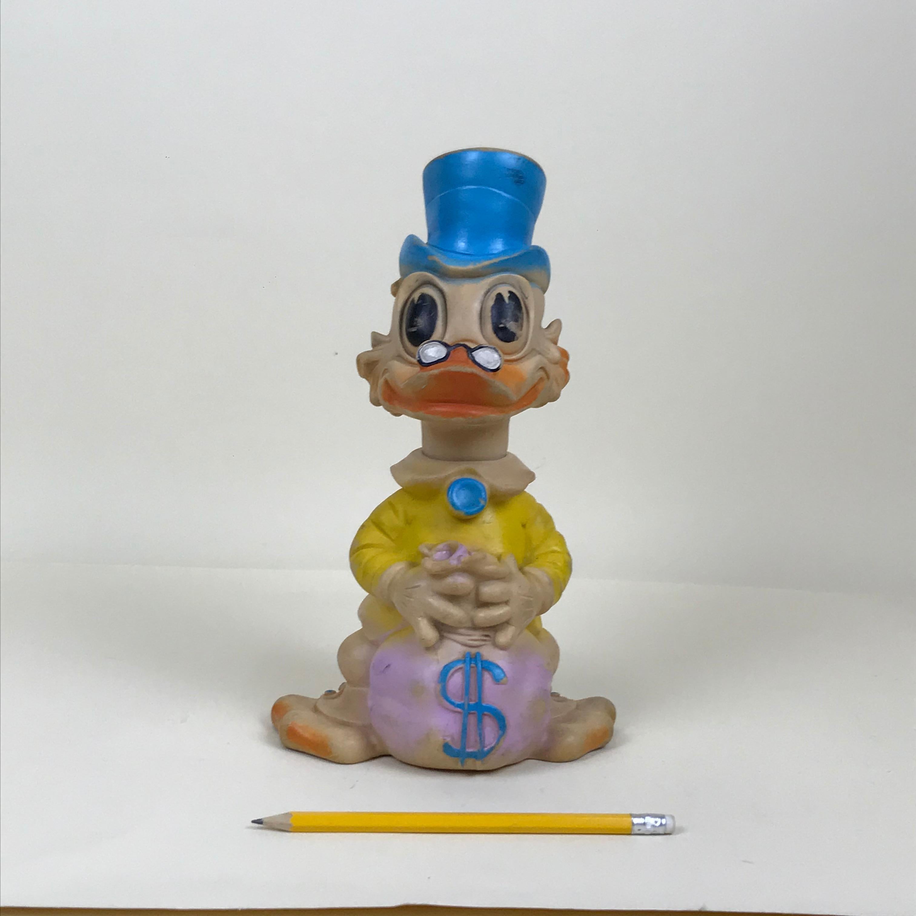 Very rare vintage yellow Uncle Scrooge squeak rubber toy with bag of coins made by Biserka in ex Yugoslavia now Croatia in the 1960s.

This model is one of the six different color model originally produced.

Marked 