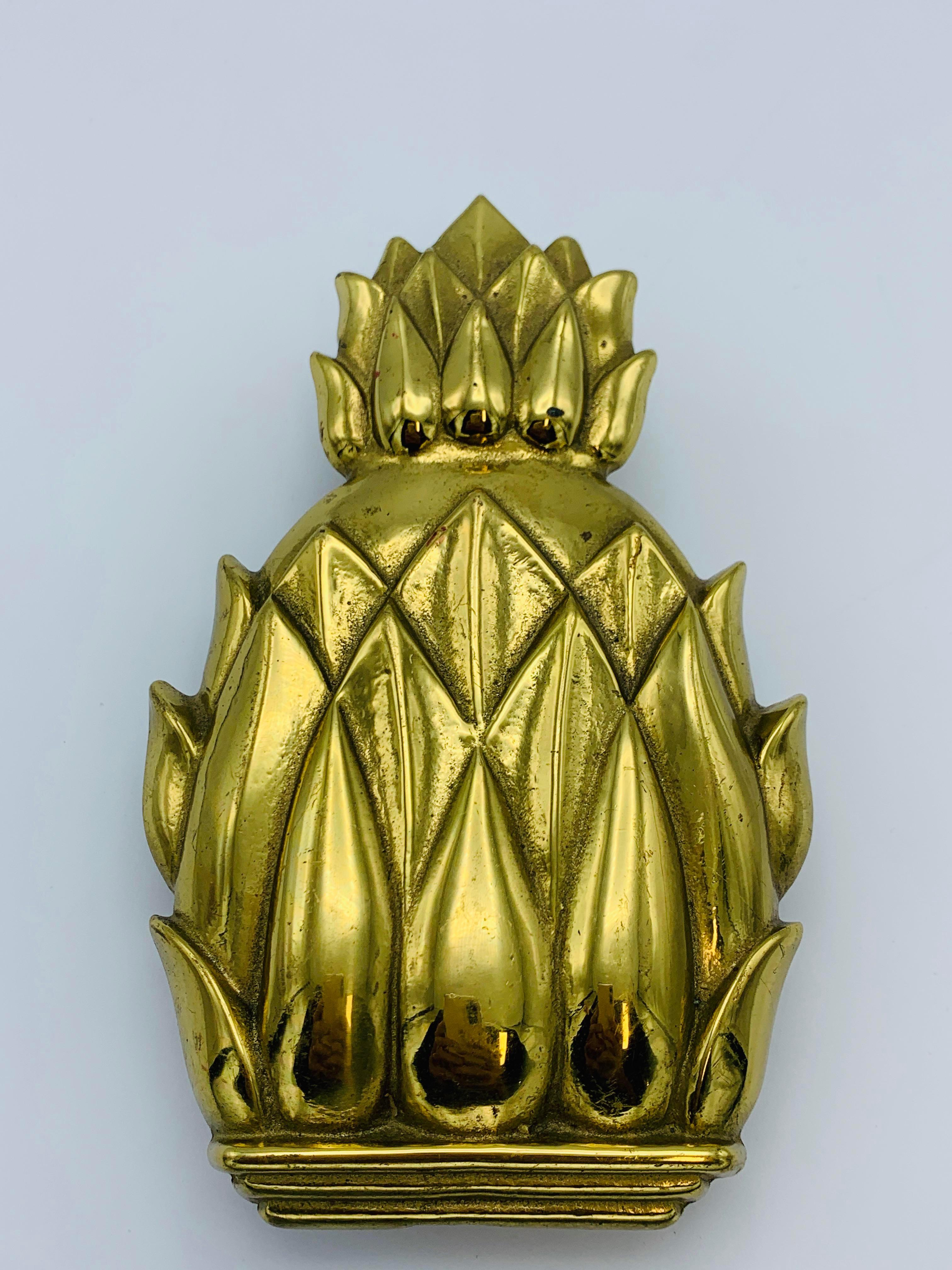 Listed is a stunning, solid-brass Virginia Metalcrafters pineapple door knocker, circa 1960s. Heavily polished and appears to have never been used. Marked on backside with Virginia Metalcrafters signature 'VMC' stamp and the pieces name and item