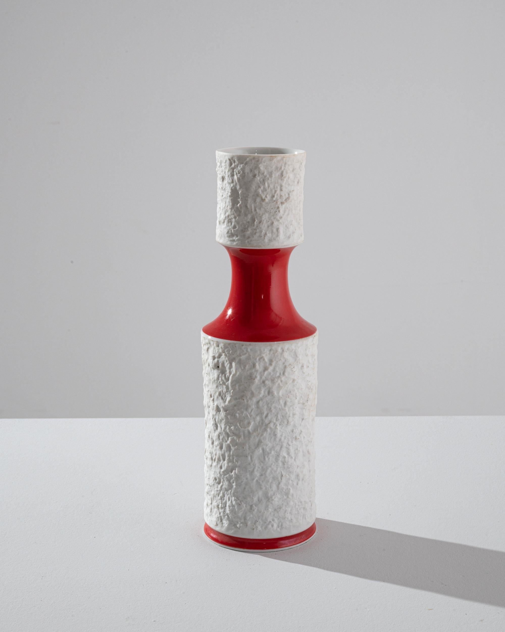 This cylindrical vase was produced in Germany circa 1960, stamped “Royal Porzellan Bavaria.” Encrusted with a tactile white glaze, sharply contrasting with a glossy red. The liquid glaze and organic form capture the fluidity of ceramic material. An