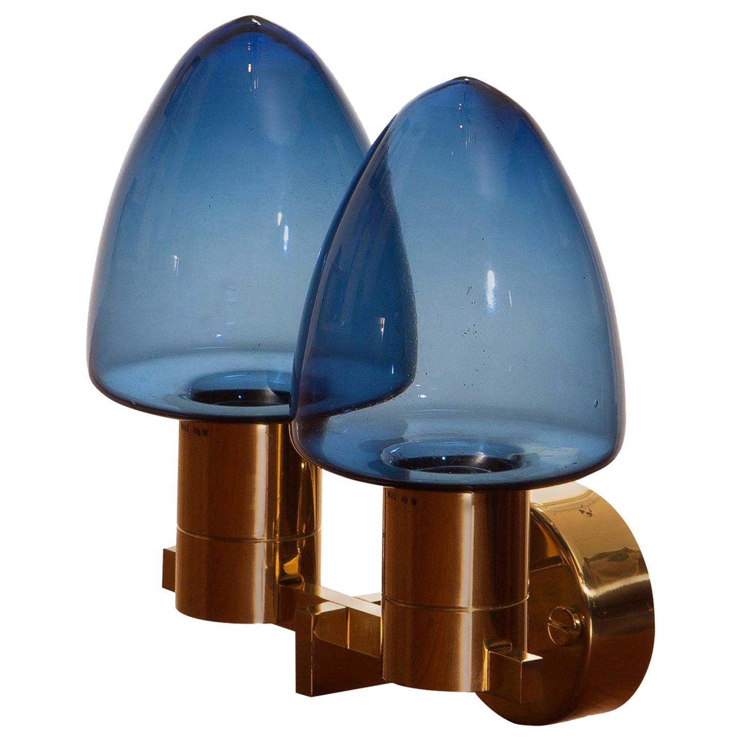 Beautiful wall light or sconce with two blue glass shades by Hans-Anne Jakobsson for Markaryd, 1960.
This wall light is, except a hairline on the back plate, in good condition.
Technically 100%.
Including mounting plate and original