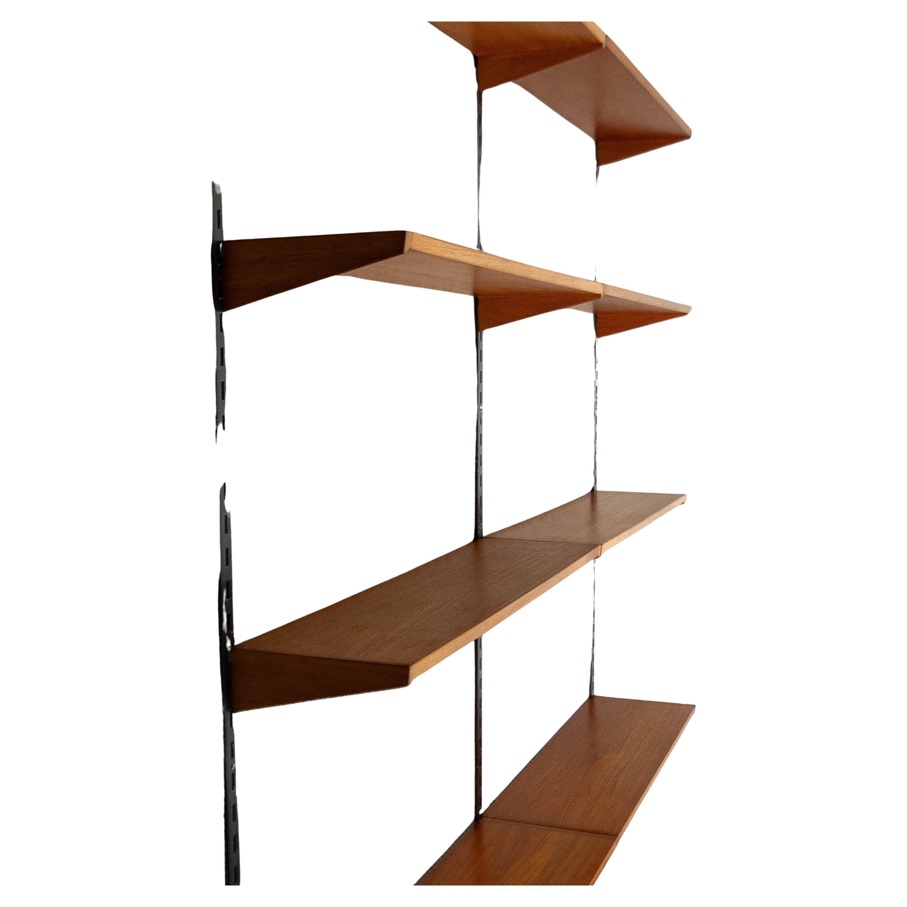 A stunning mid-century modern shelving system, designed by Kai Kristiansen and produced by FM Møbler, Denmark.

Design: Elegant and minimalist, with a modular structure
Material: High-quality teak wood shelves with black metal