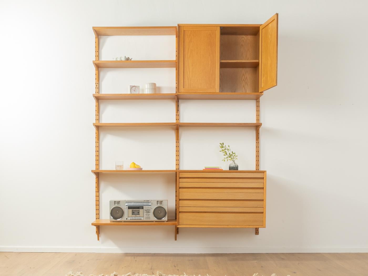 Klassisches Regalsystem aus den 1960er Jahren. Die hochwertigen Behälter und Regale sind in Eiche furniert. Das System besteht aus sieben Regalen, einem Container mit Schubladen, einem Container mit Türen und drei