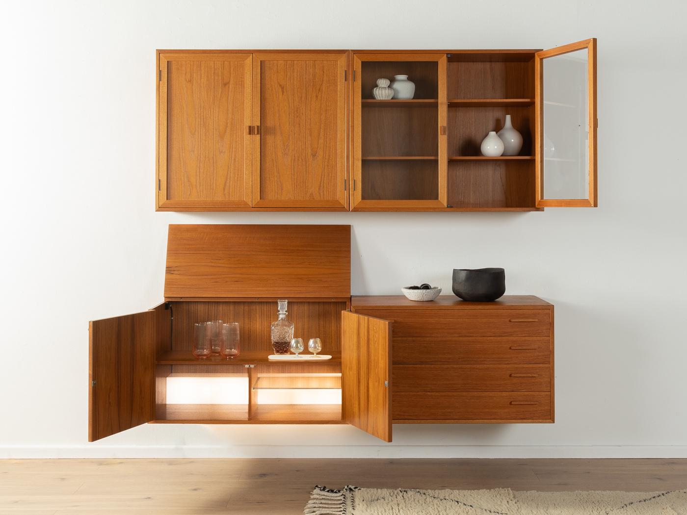 Classic shelving system by Kai Kristiansen for FM Møbler from the 1960s. The high-quality containers are veneered in teak. The system consists of one container with doors and four shelves, one container with four drawers, one container with two