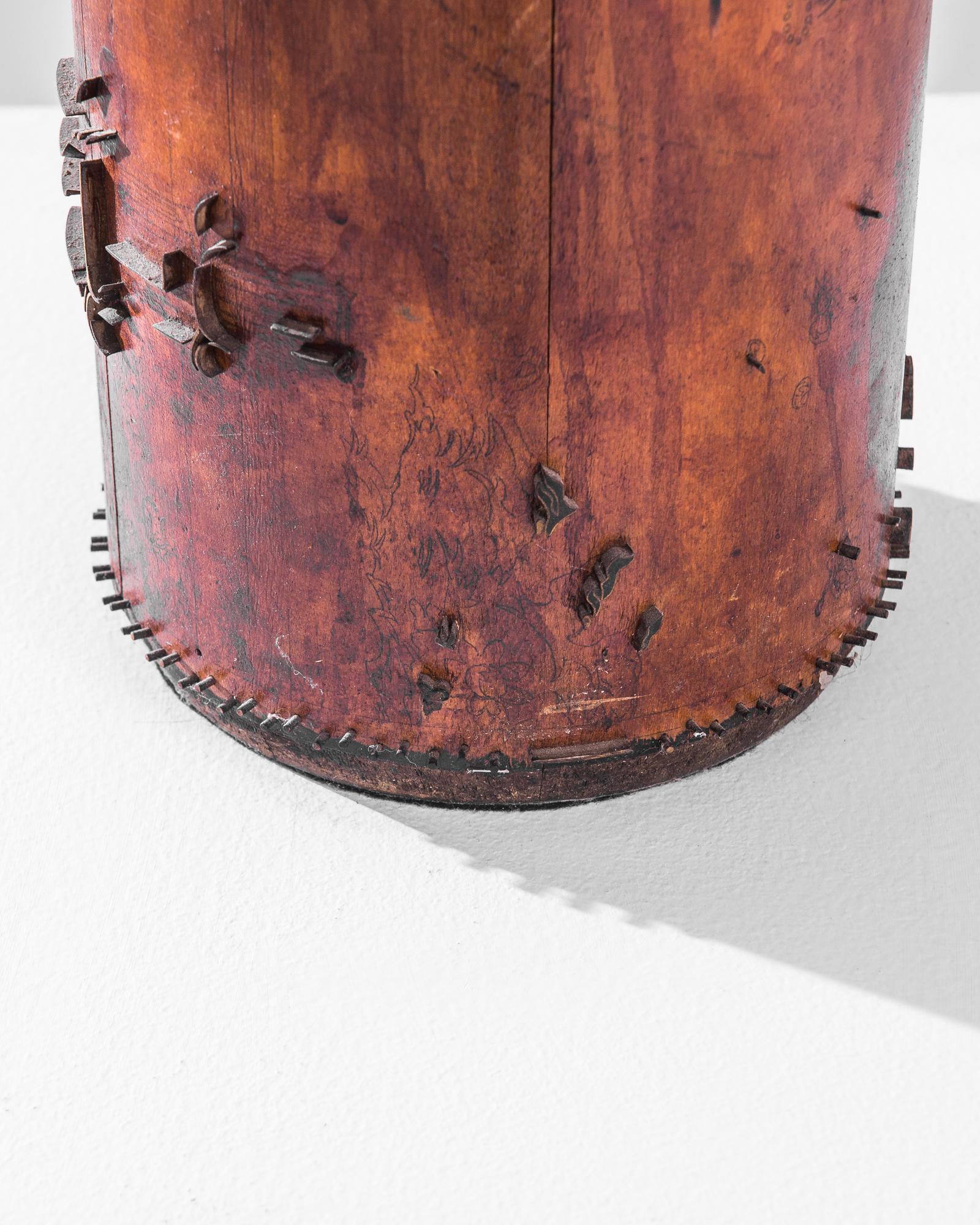 Une lampe de table en bois de France, produite vers 1960. Un cylindre de bois d'un mètre de haut, coiffé d'un anneau noir incliné et d'une couronne de chevilles saillantes, avec un motif abstrait en relief ombragé et doré en laiton. Adapté d'un