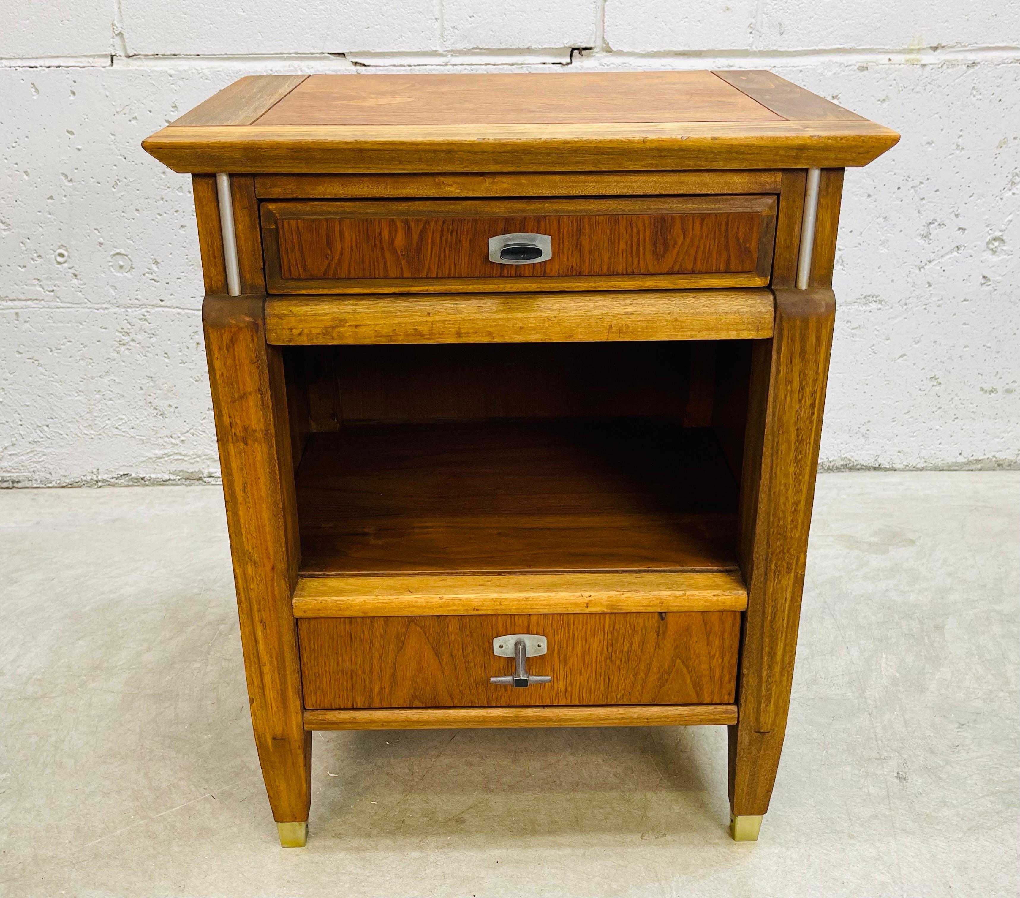 Vintage 1960s walnut and elm wood nightstand. The nightstand has a two drawers for storage and open storage in the middle. The drawer pulls are metal with and industrial design. Marked in the drawer.