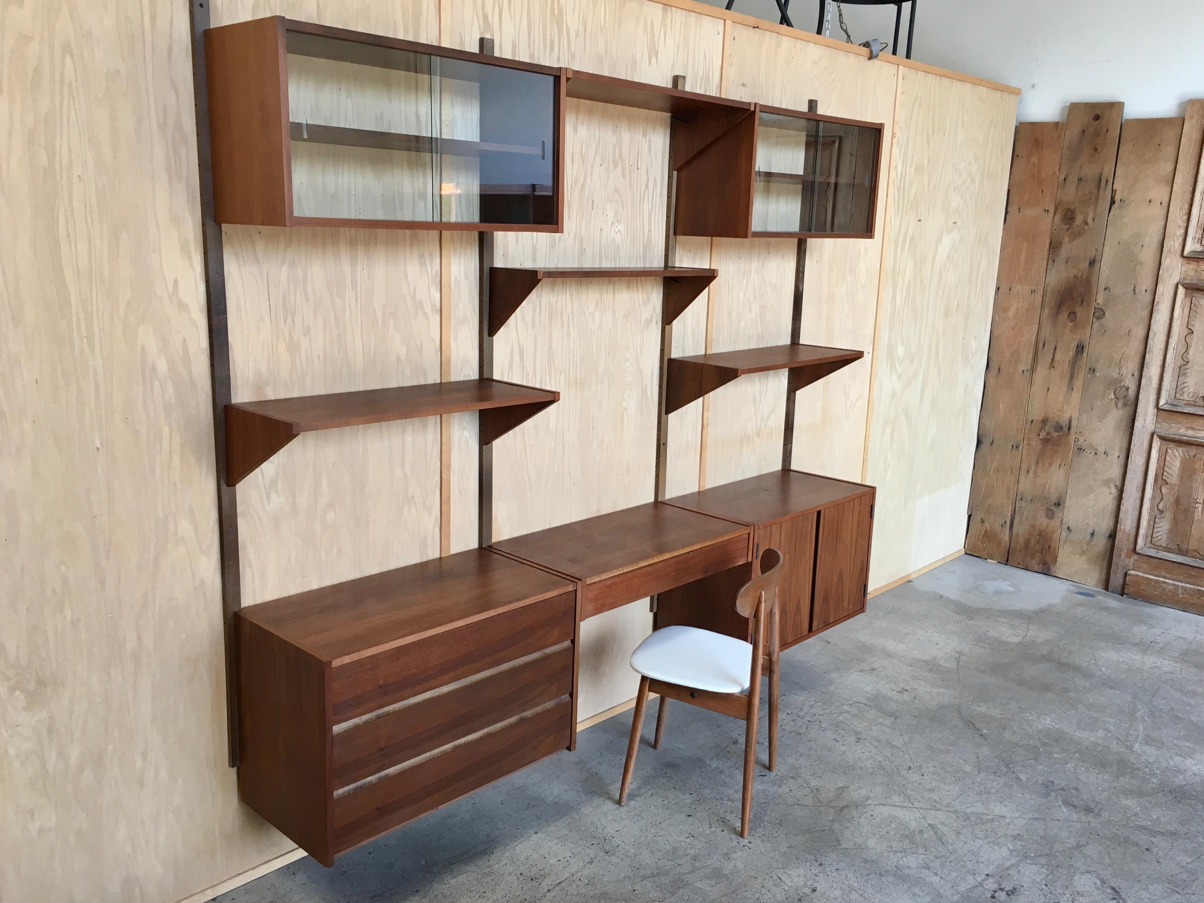 Hanging walnut 3-bay wall unit with fully adjustable cabinets and shelves.