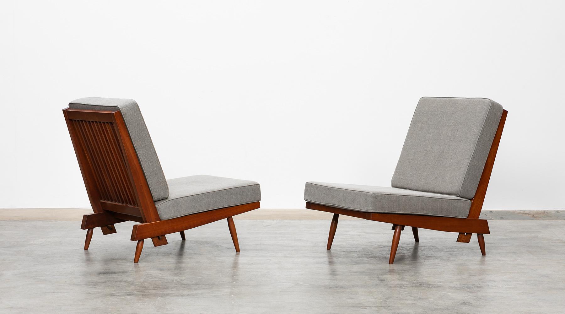 Lounge chairs, walnut, new upholstery in grey by George Nakashima, USA, 1962.

Magnificent set of lounge chairs crafted from American walnut by George Nakashima himself in elaborate handwork. The light feet and frame combined with the generous