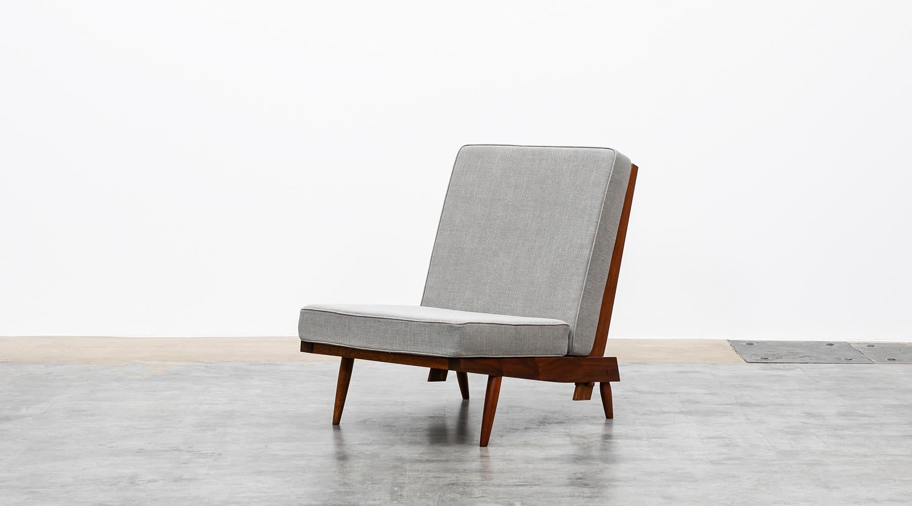 Lounge chair in walnut, new upholstery in grey by George Nakashima, USA, 1962.

Magnificent single lounge chair crafted from American walnut by George Nakashima himself in elaborate handwork. The light feet and frame combined with the generous