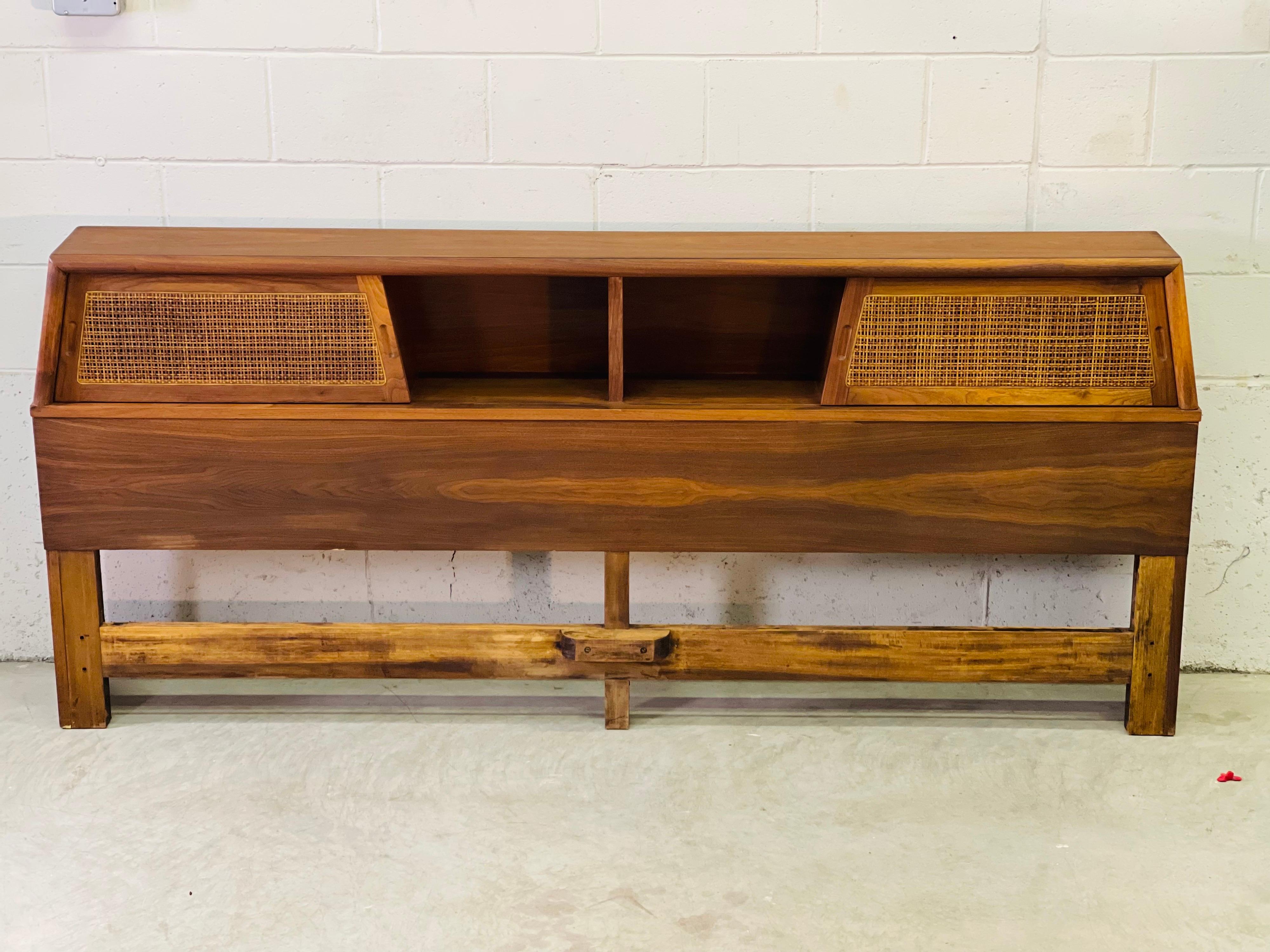 Vintage 1960s walnut wood king size headboard with sliding cane doors. The headboard has ample storage and comes with a third extra door. Door slide easily. Side rail holes are 78” apart. No marks.
