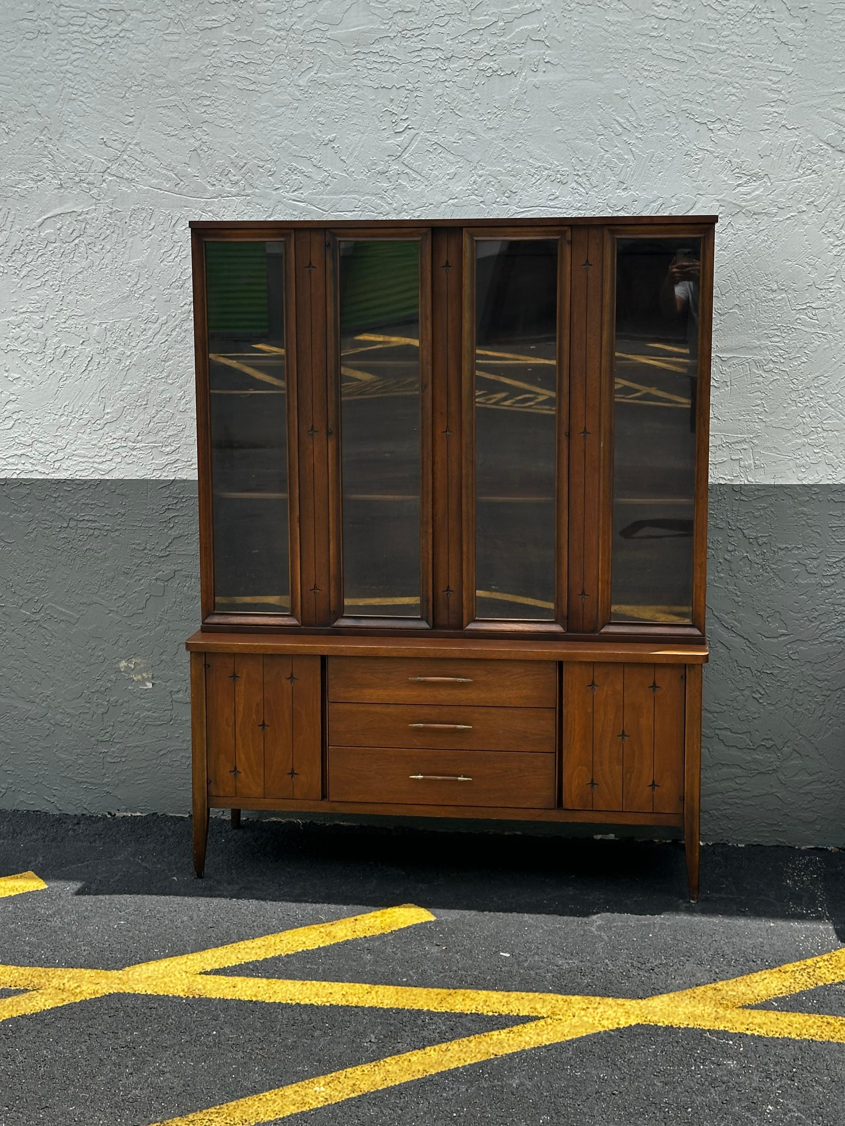 Beautiful, retro Mid-Century Modern detailed proportioned walnut Broyhill, Saga, buffet China cabinet in great original condition. The hutch is one solid-piece, featuring two sliding glass doors on top that open to reveal a beautiful interior with