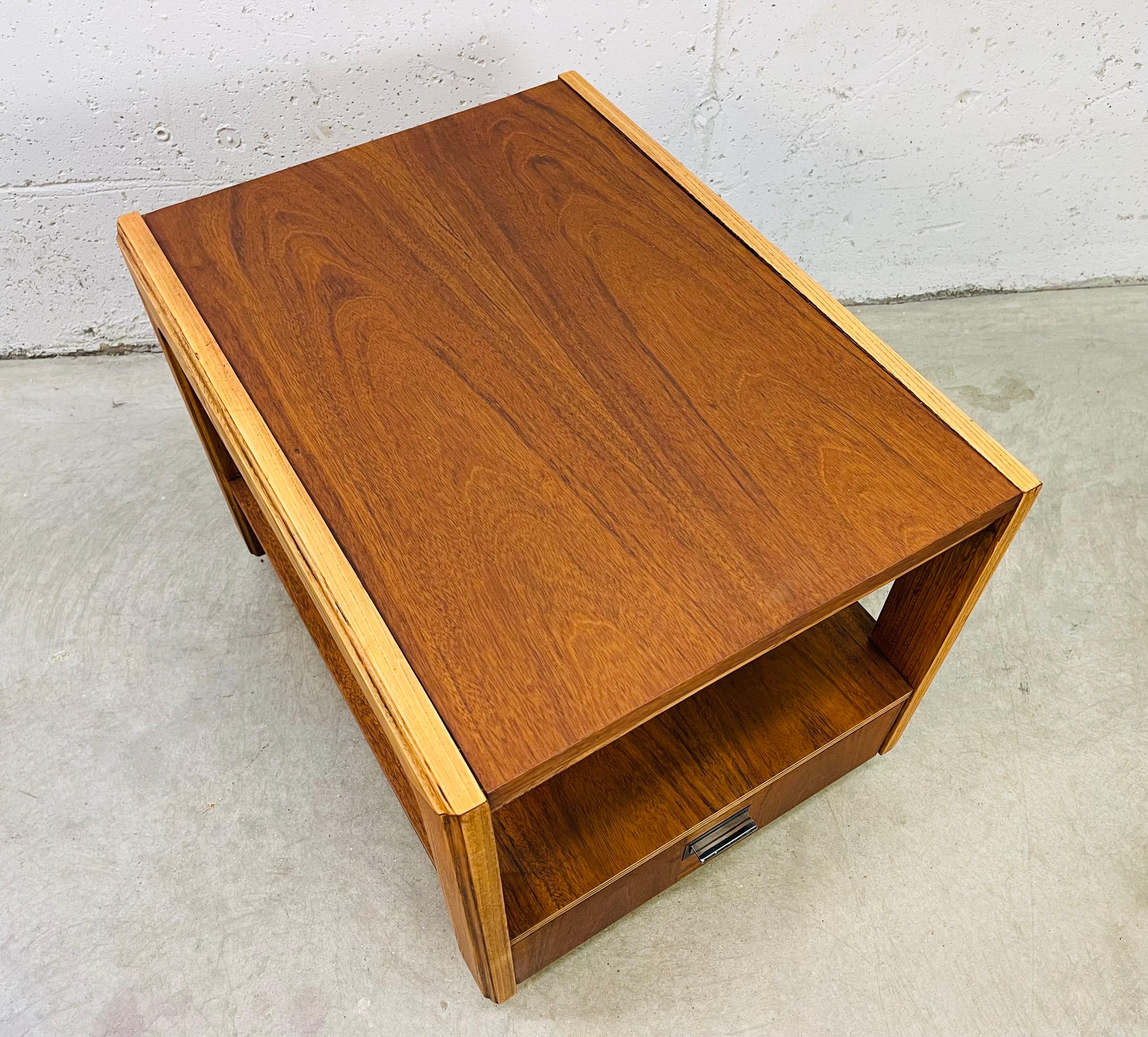 Vintage 1960s walnut and ash wood rectangular side table with a drawer for storage. The drawer has a chrome pull. The table also has an open area for storage. Newly refnished condition. Marked in the drawer.