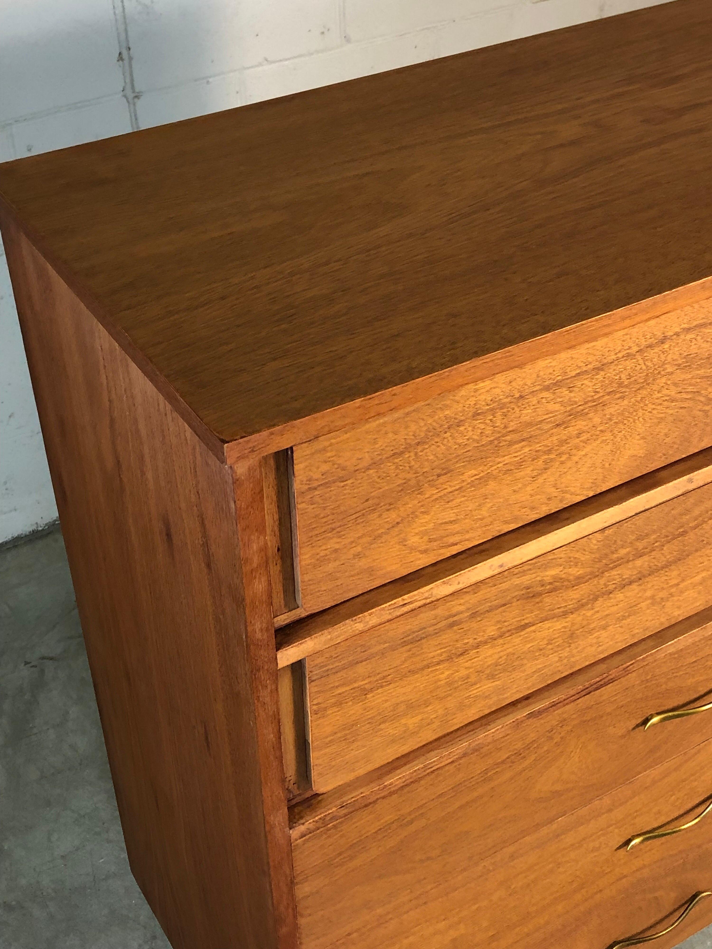 Mid-Century Modern 1960s walnut dresser with five drawers for mainline by Hooker Furniture Co. The dresser also has the original brass pulls. It is in newly refinished condition. Marked in the drawer.