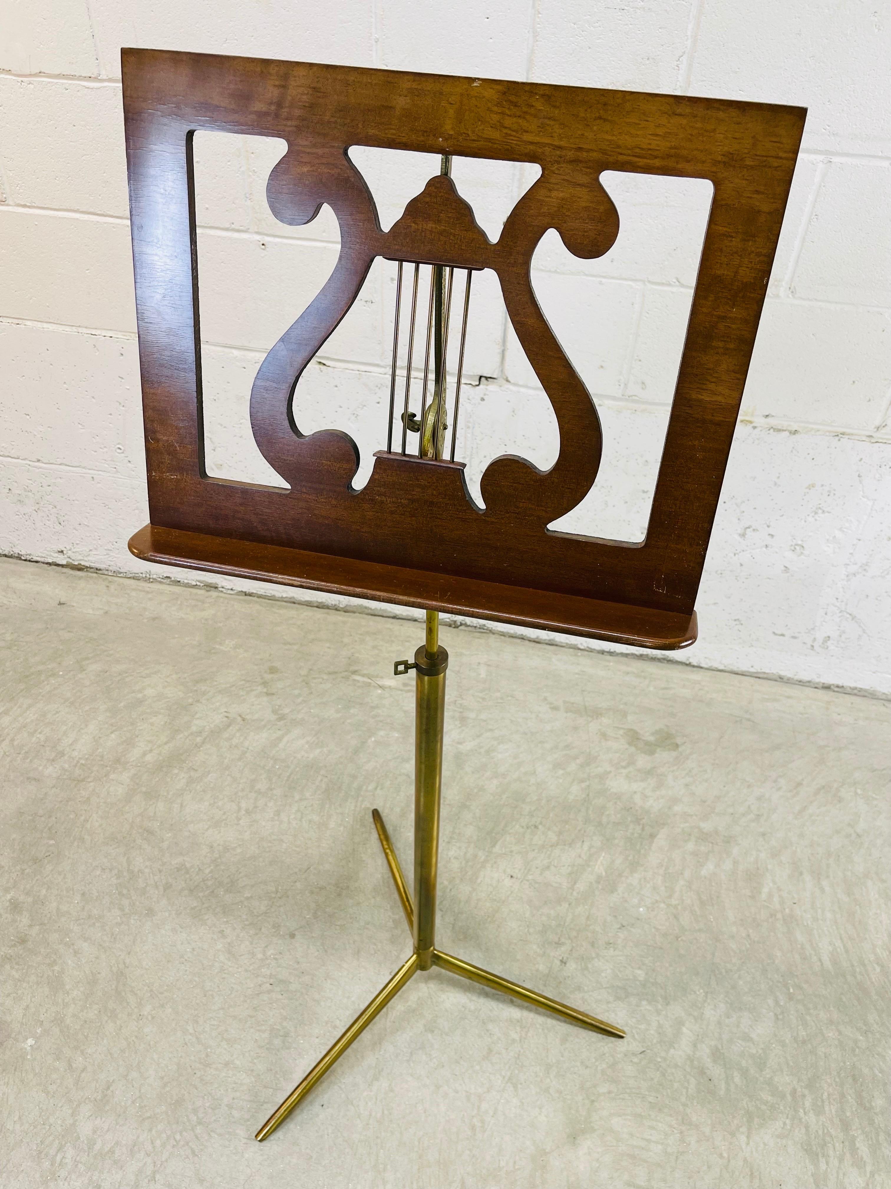 1960s Walnut wood and gold metal base sheet music stand. The sheet music holder is adjustable up and down and back and forth. The walnut holder measures 17.5”W x 14”H. It adjusts down to 40”H and as high as 50”H. No marks.