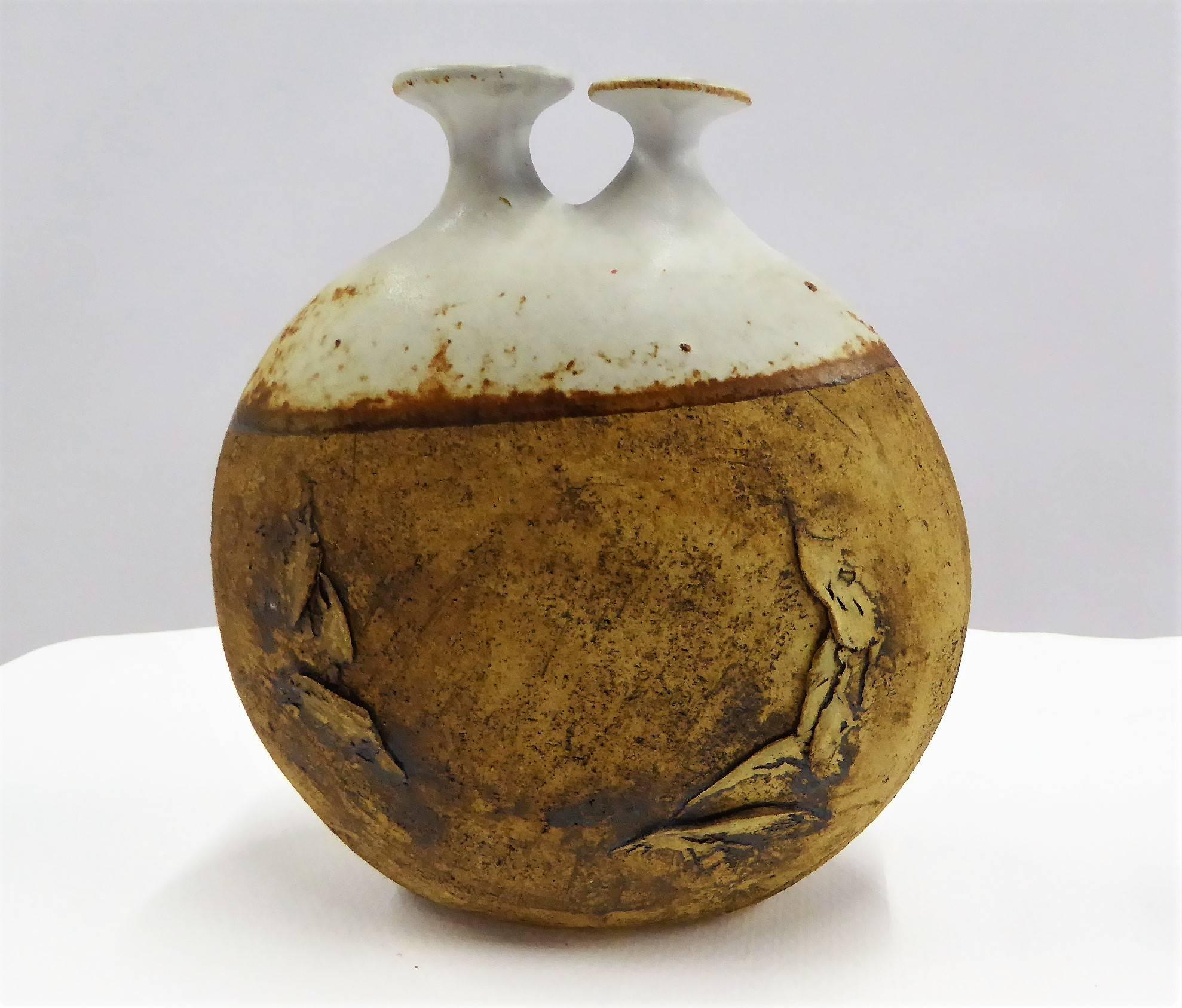REDUCED FROM $475.....1960s art pottery vessel by Warren Hullow of Hickory Grove Studios. Fairly rare, it is a wide stoneware weed pot or twig vase with unglazed lower half and the upper glazed with a pair of spouts. Well known, he collaborated with
