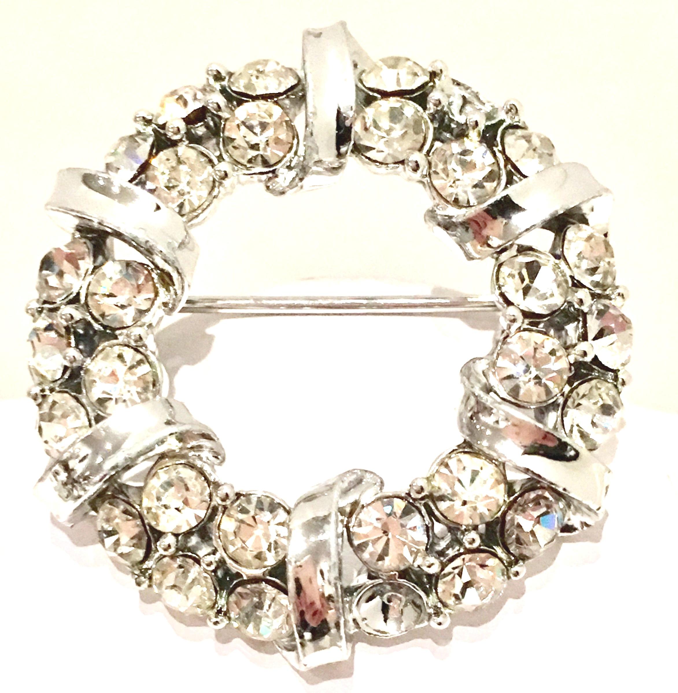 1960'S Silver & Swarovski Crystal Dimensional Brooch, In The Style Of Weiss.
This dimensional silver rhodium plate round brooch features silver ribbon twist detail with brilliant colorless Swarovski crystal cut and faceted prong set round stones. 