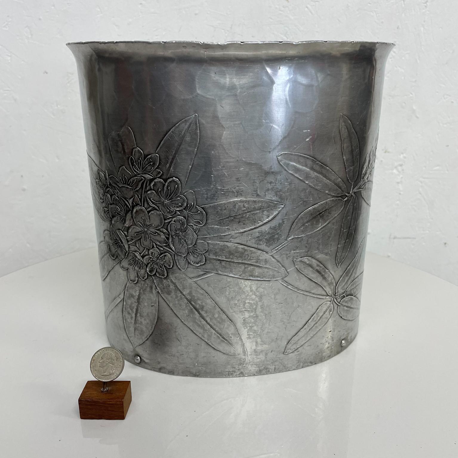 Waste basket
1960s Wendell August Forge Floral Motif Waste Basket in Hammered Aluminum Grove City PA
Maker Stamped on the bottom.
Preowned original vintage condition.
Measures: 10 w x 7.5 d x 10 tall
See provided images.