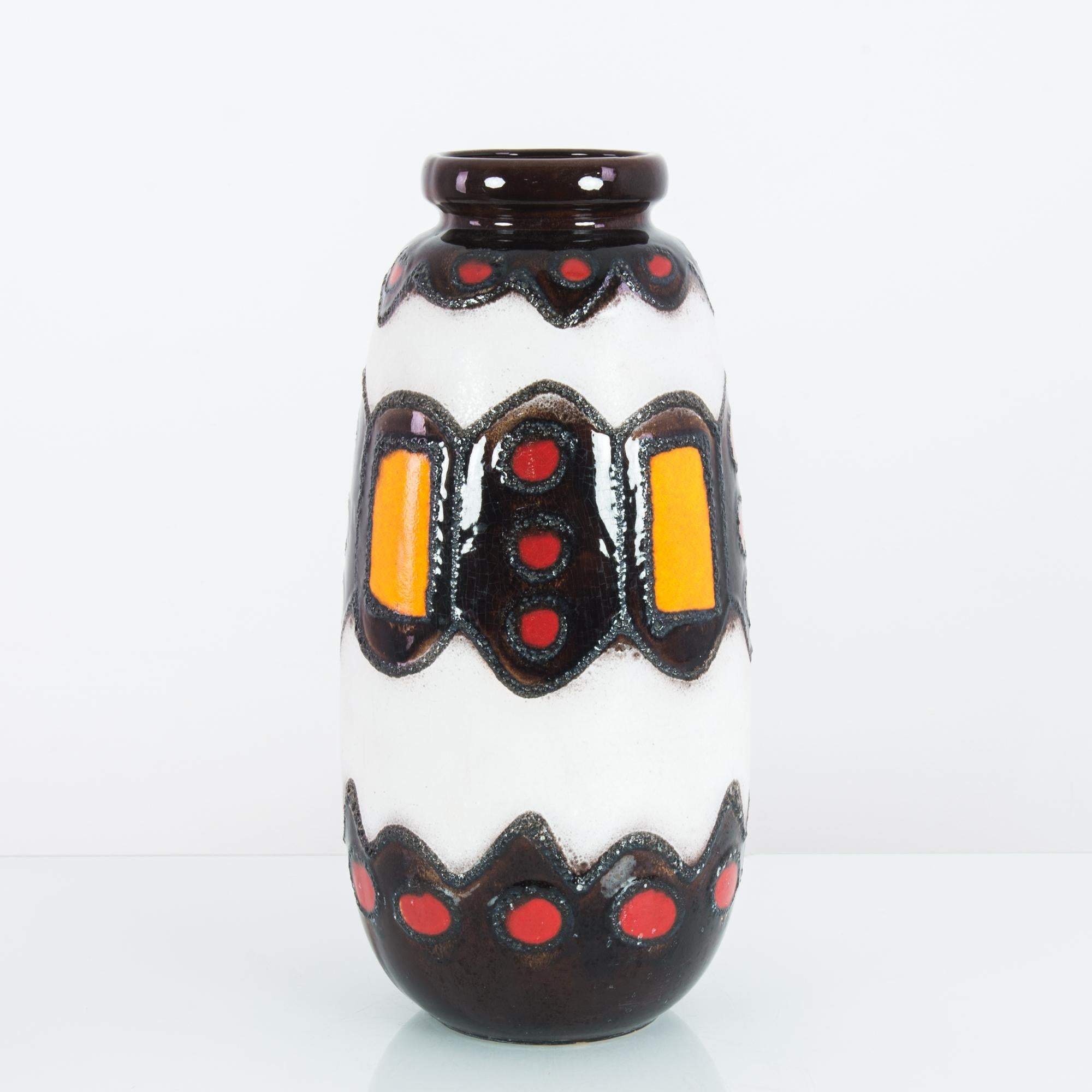 A ceramic vase from West Germany, produced circa 1960. A ceramic vase in thick, vibrant, glistening glaze. Sharp juxtaposition of white crisply outlined against the brightly patterned dark brown almost black bands make this piece pop. The influence