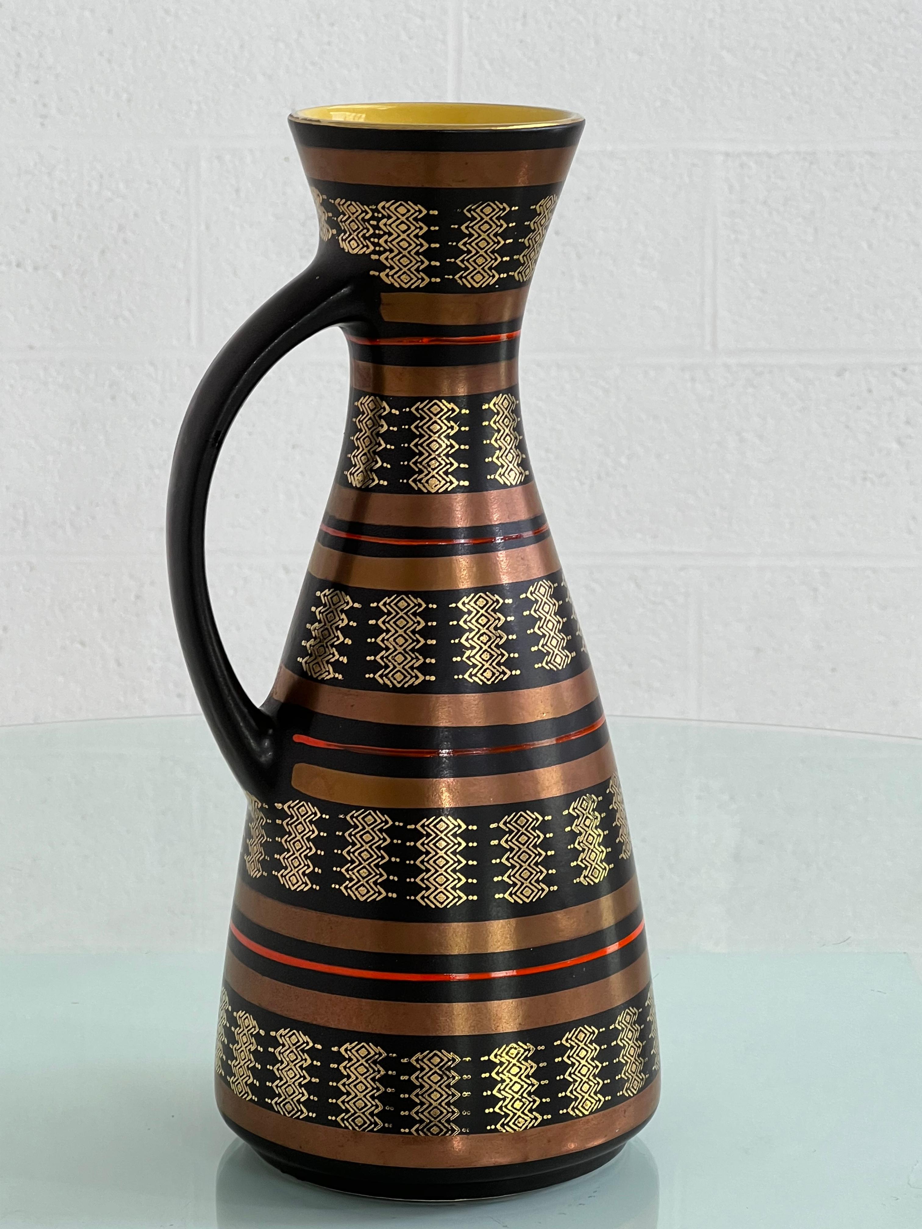 Vase pichet en céramique fait à la main dans les années 1960 en Allemagne de l'Ouest avec des couleurs noires, rouges, cuivre et or à l'extérieur et une glaçure jaune étonnante à l'intérieur.