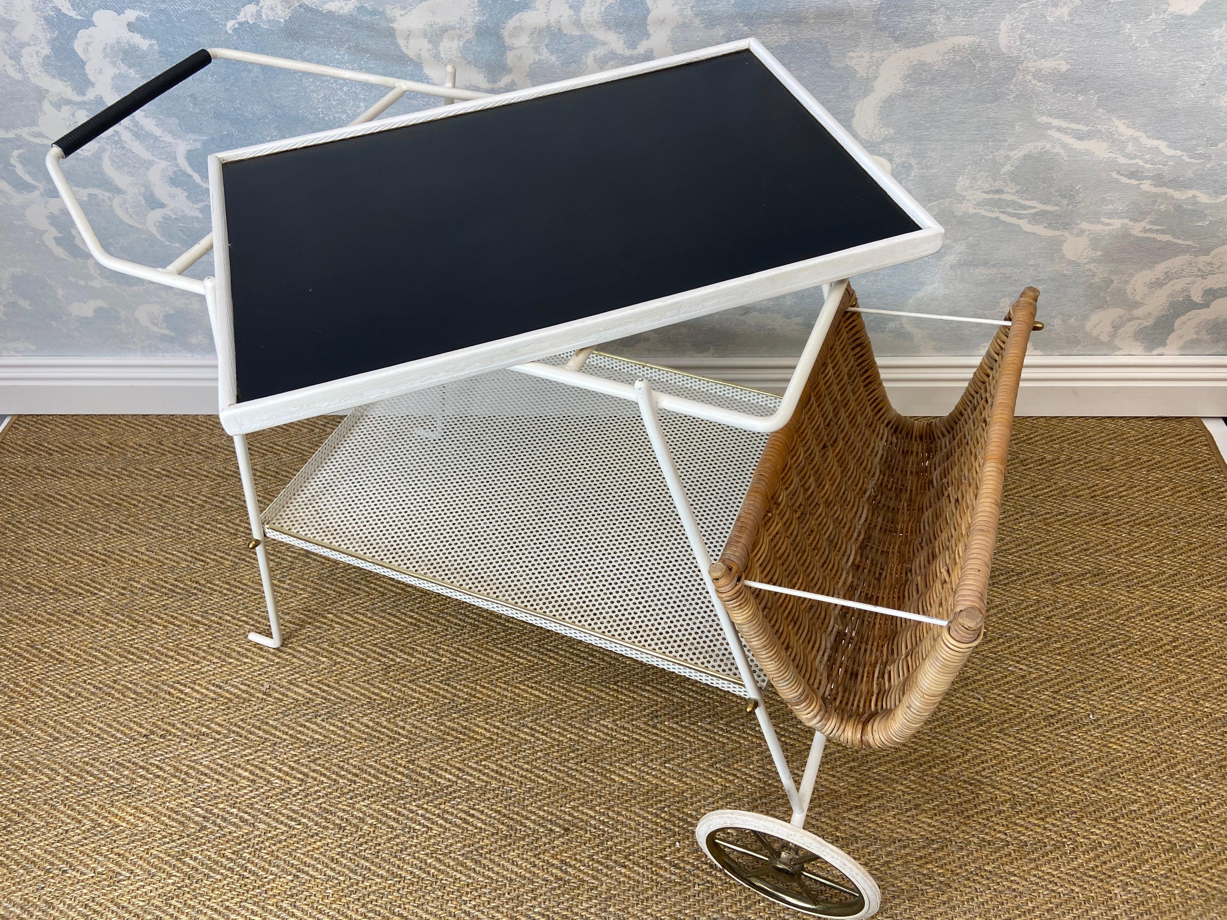 This rather unique tea trolley or bar cart with a wicker basket probably hails from France in the mid 1960's. The simple lines and black and white color scheme along with the reed basket make this bar cart a suitable companion for indoor and outdoor