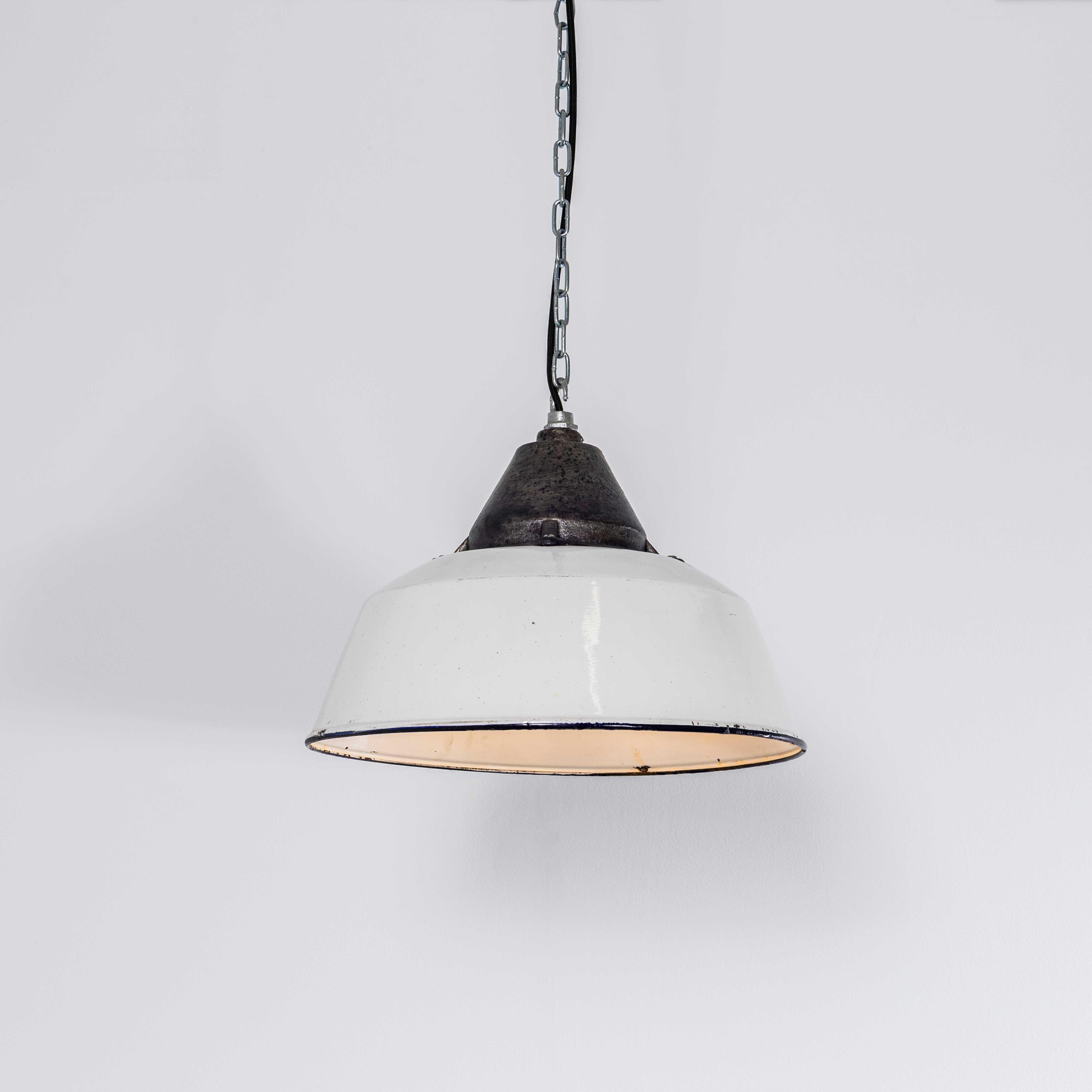 Lampe pendante industrielle en fonte blanche et émail des années 1960. 
Lampe industrielle classique d'Europe de l'Est, l'abat-jour et le réflecteur sont émaillés de blanc, le sommet est une importante galerie en fonte. La lampe a été nettoyée et