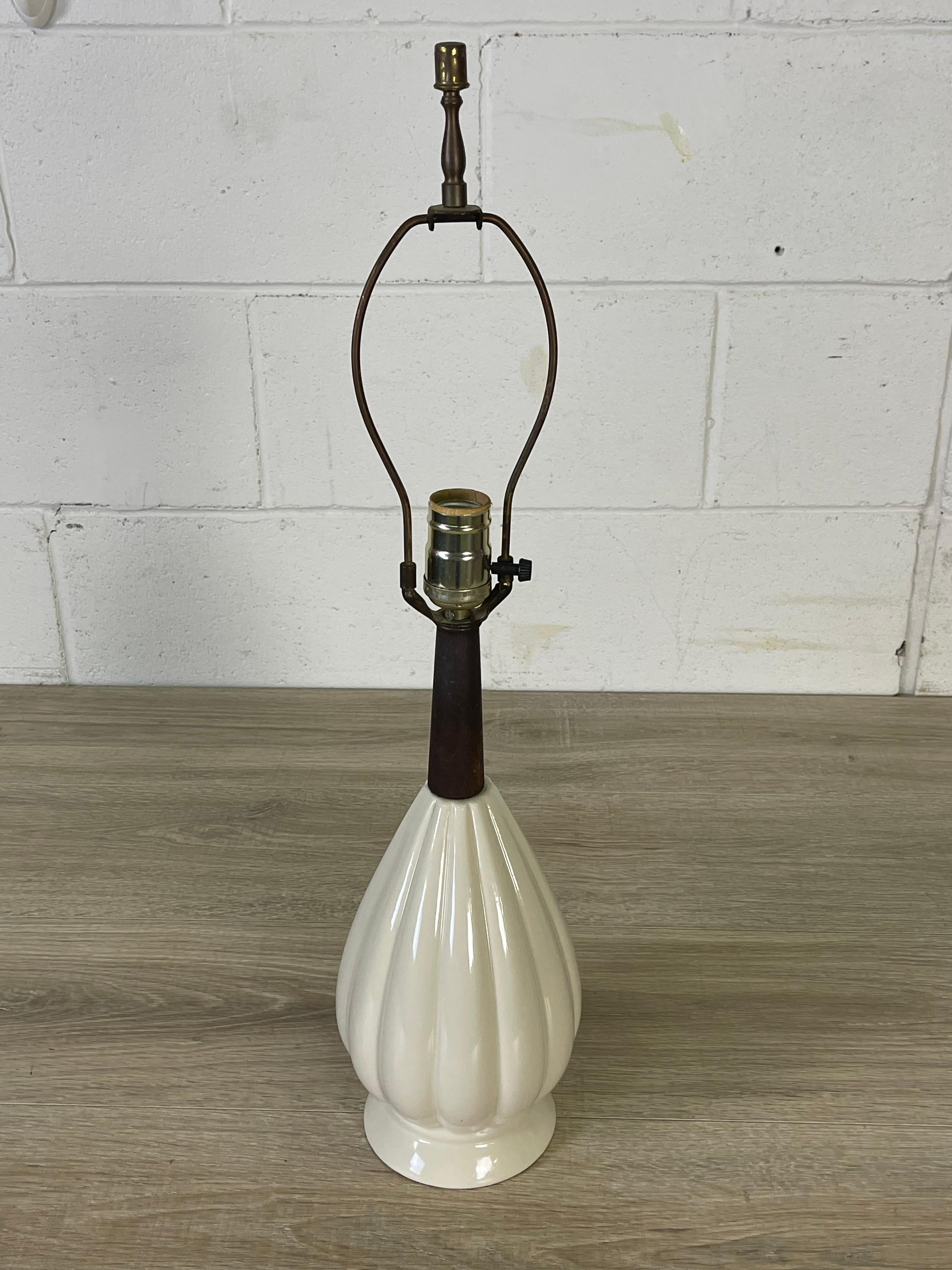 Vintage 1960s white ceramic table lamp with a dark walnut wood neck. Wired for the US and in working condition. Lamp uses a standard 100 watt bulb. Socket, 16”H. Harp, 4”Dia x 7”H. No marks.