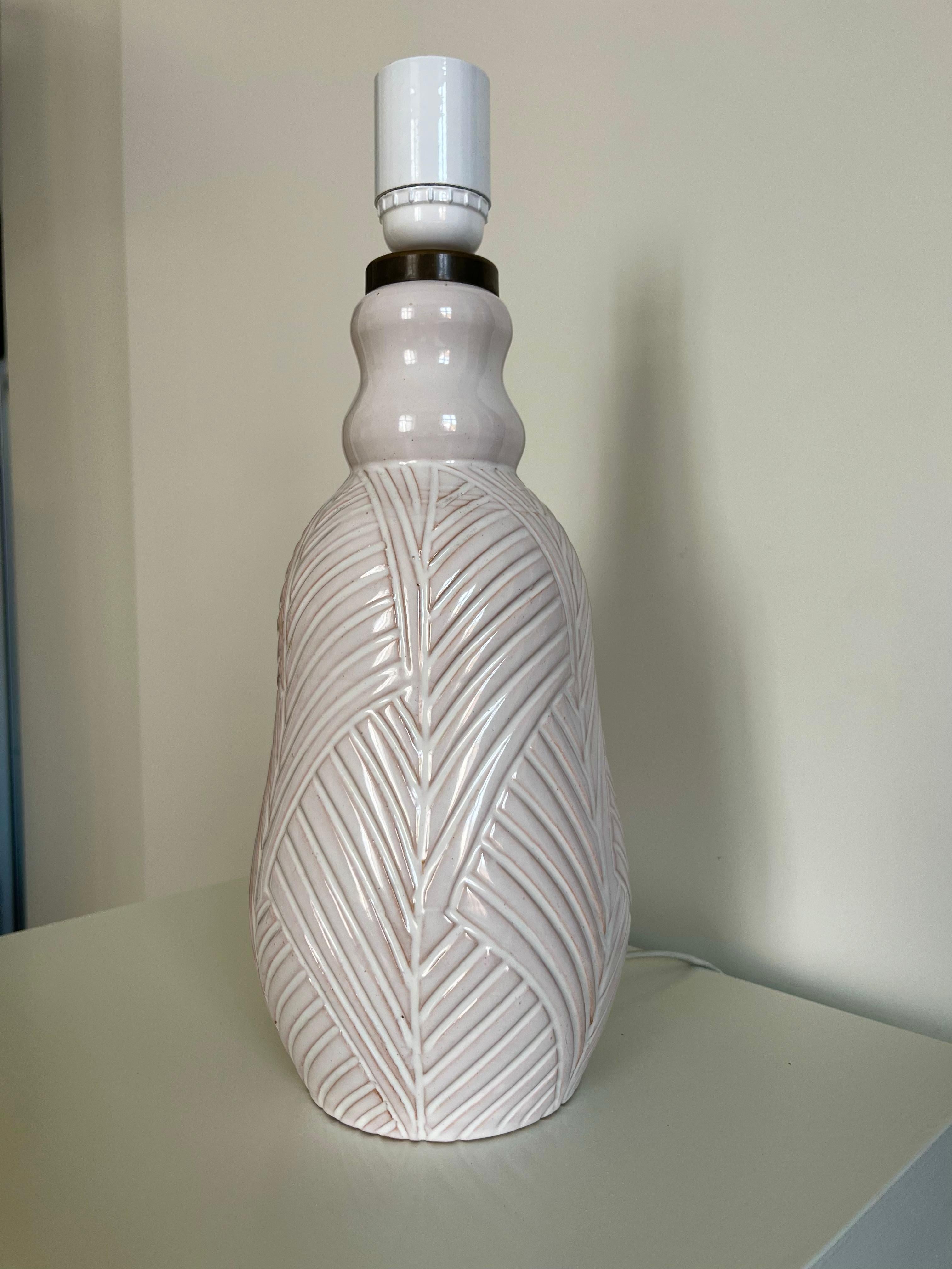 Cette lampe de table des années 1960 en céramique émaillée blanche avec des décorations gravées a été fabriquée par la poterie danoise Aristo. 

Hauteur : 34 cm avec le rameau.