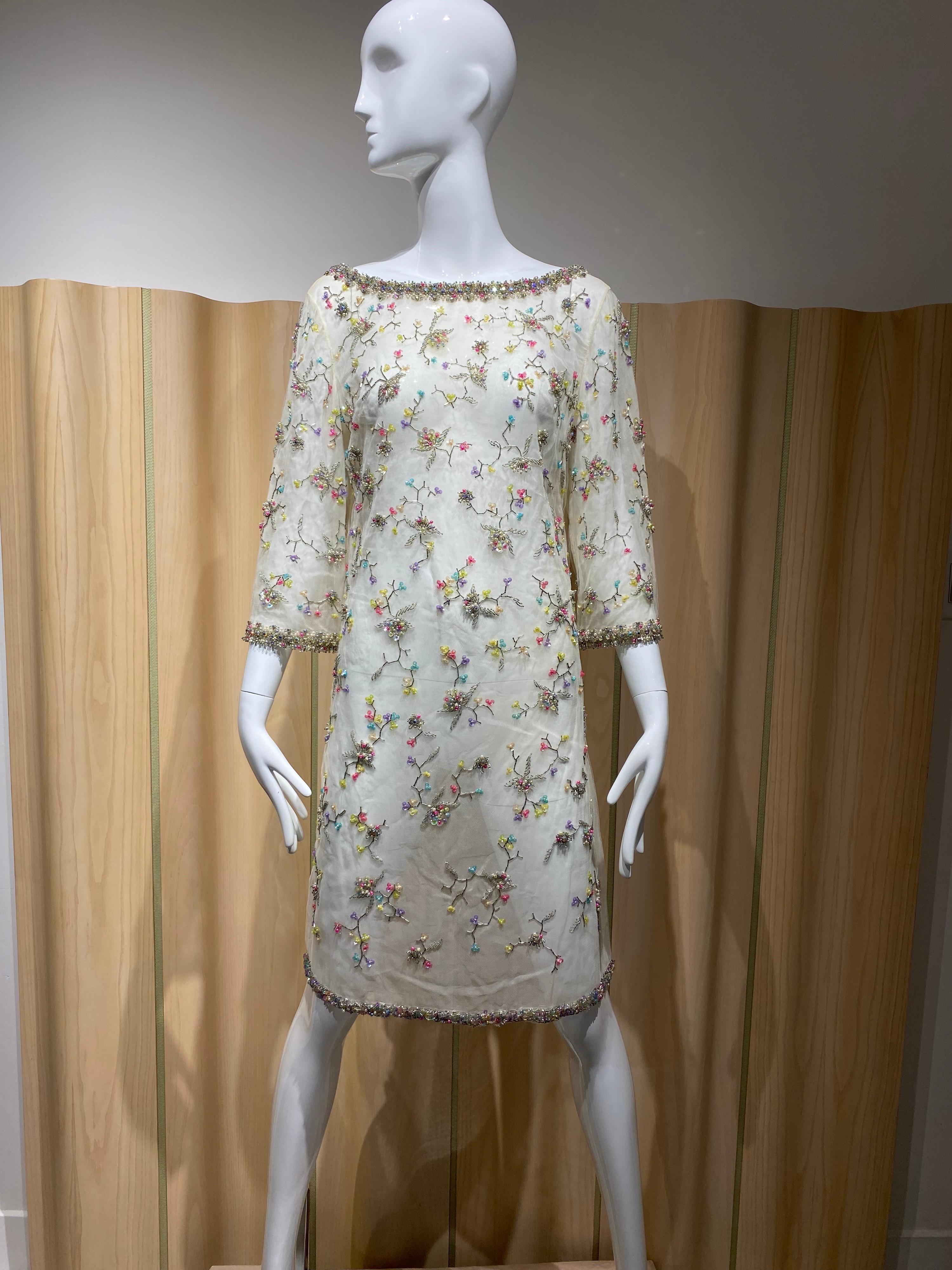 robe de cocktail fourreau en filet blanc des années 1960, ornée de perles multicolores à motif floral. Taille moyenne à grande 

Mesure :
Poitrine : 38