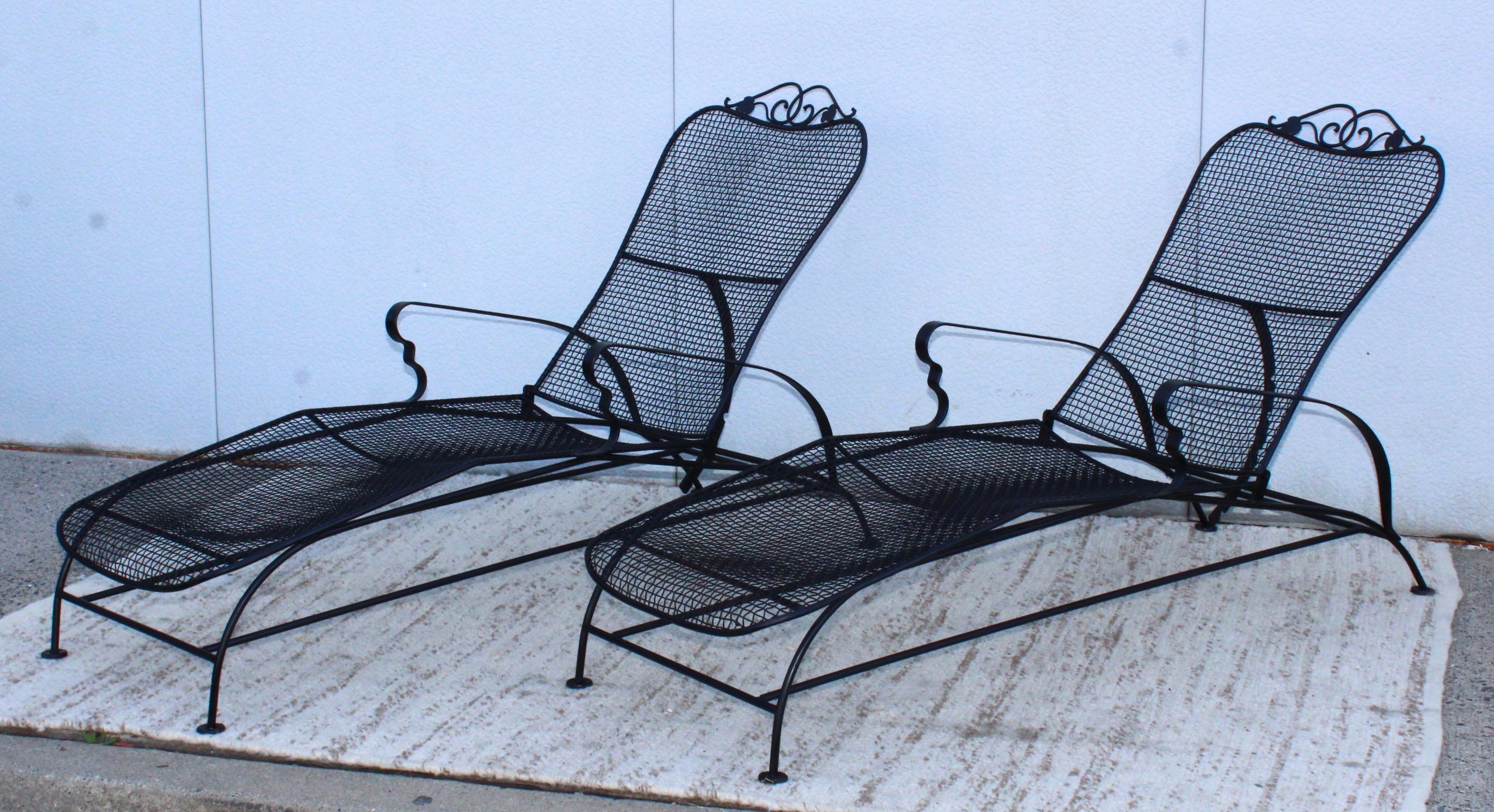 Stunning pair of 1960's well made iron and wire mesh outdoor chaise lounges with adjustable back. In vintage original condition with some wear and patina due to age and use.