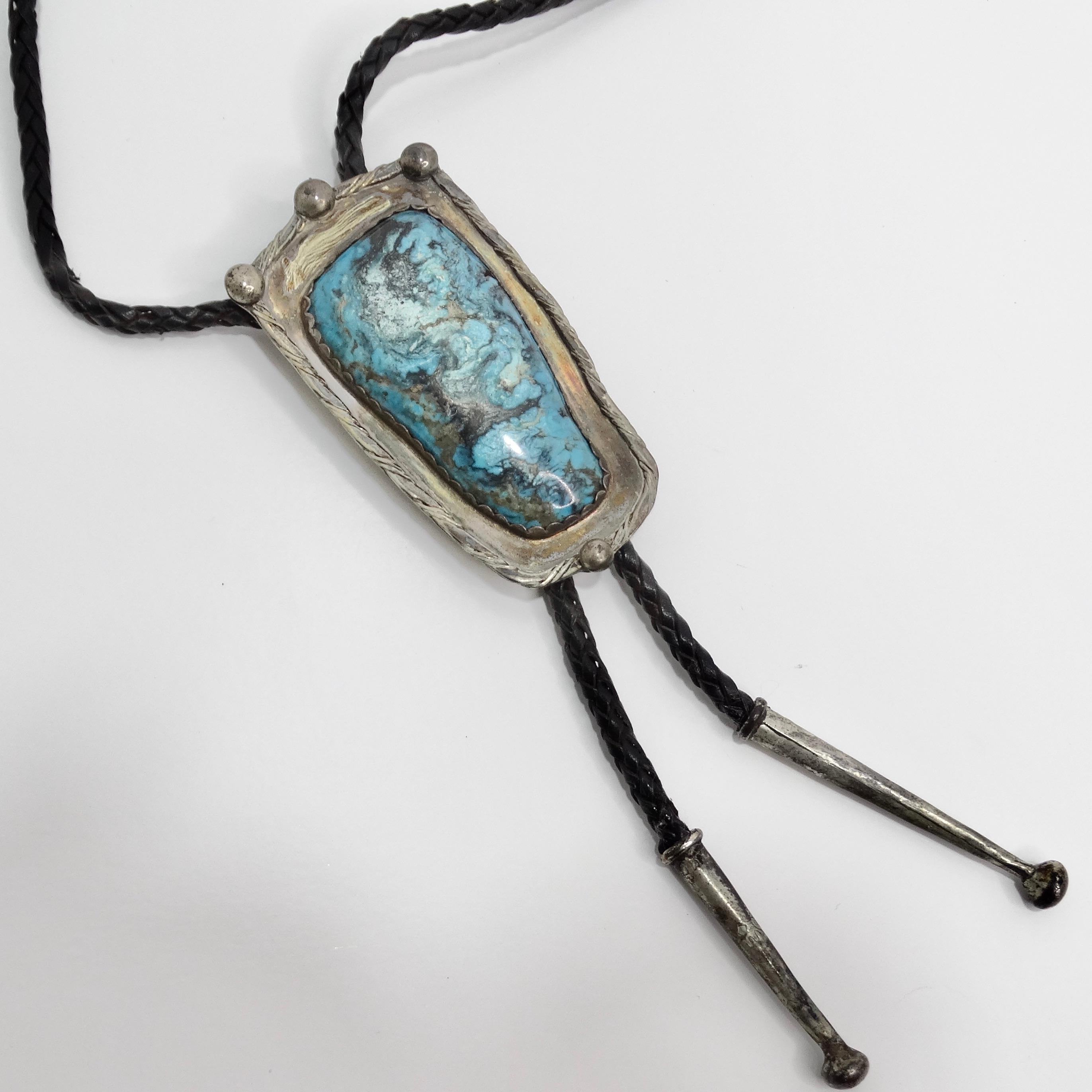 Die 1960er Native American Silver Turquoise Bolo Necklace ist ein fesselndes Stück, das die reiche Tradition und Handwerkskunst der amerikanischen Ureinwohner widerspiegelt. Diese atemberaubende Halskette im Bolo-Stil zeigt einen wunderschön