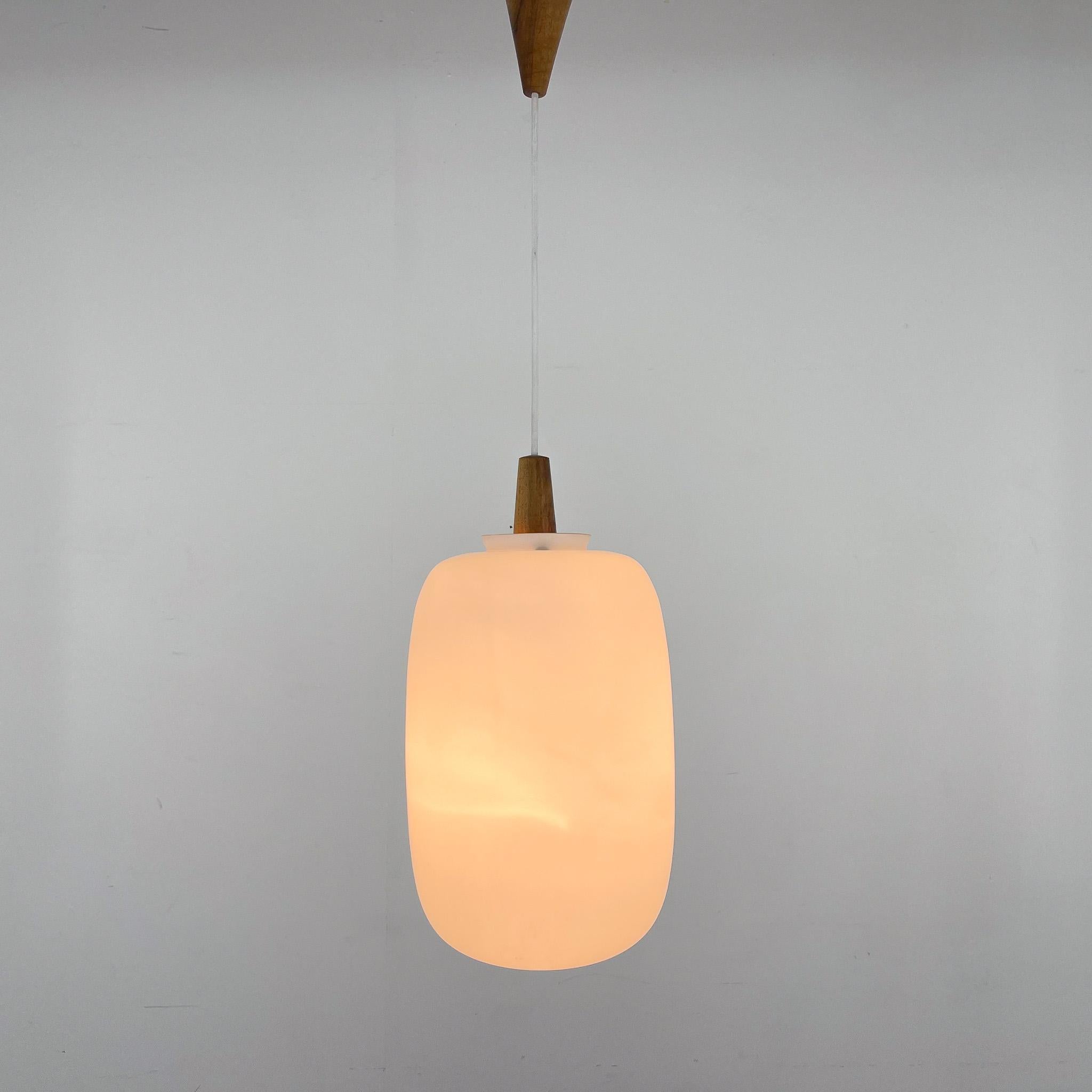 Elegant midcentury pendant light by ULUV made from wood and milk glass. Produced in former Czechoslovakia in the 1960s. 
Good vintage condition. 1x  E25-E27 sockets. US wiring compatible. 