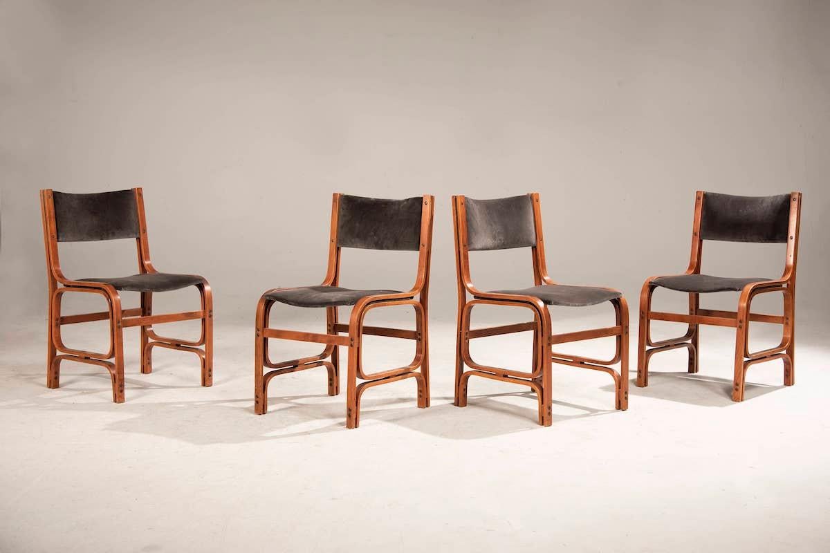 Four wooden and velvet chairs from the 1960s. The chairs have a wooden frame with a very rare shape. 

The cushions are made of aubergine velvet and have been reupholstered new. The very special feature of these upholstered chairs is that they are