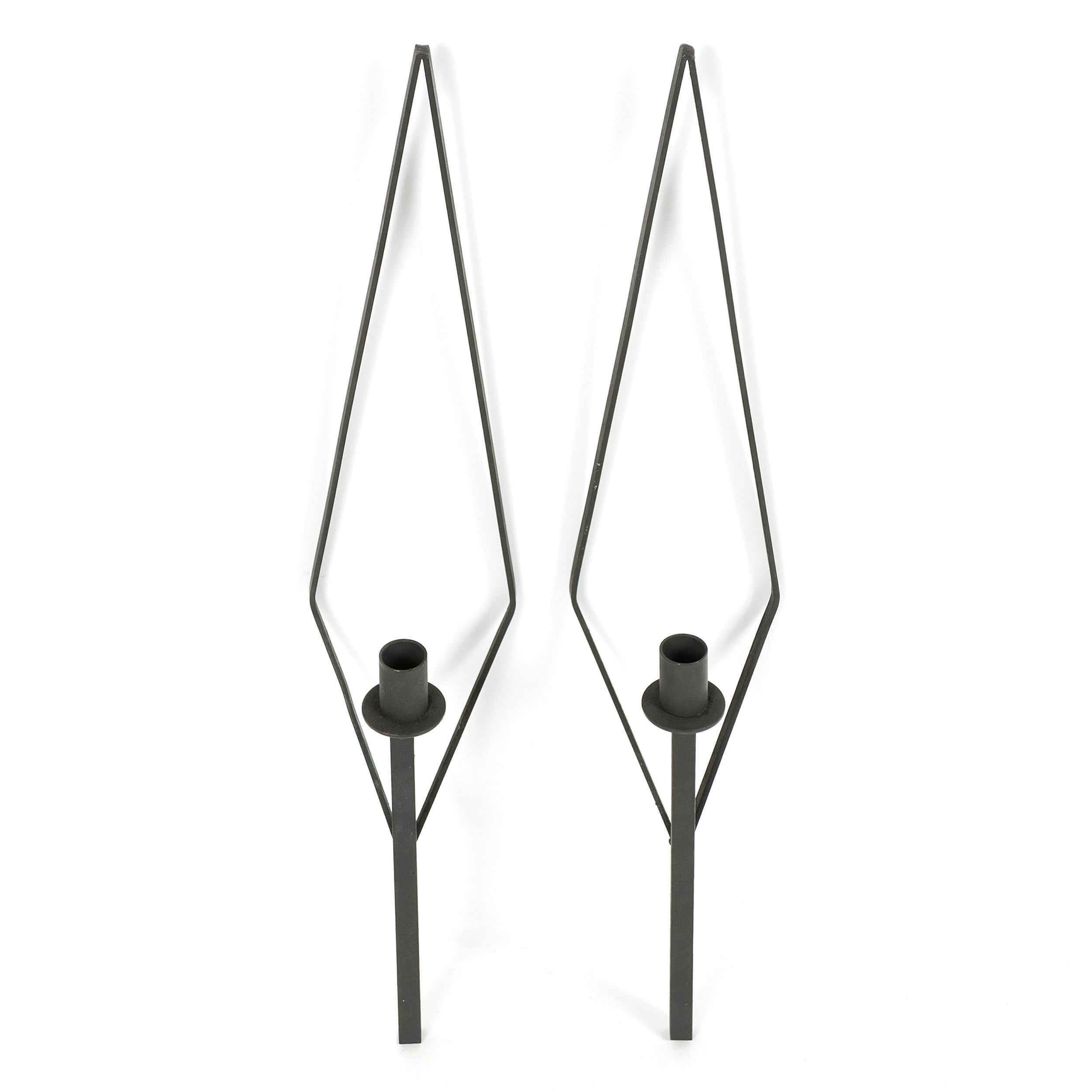 A pair of geometric wrought iron candle sconces.