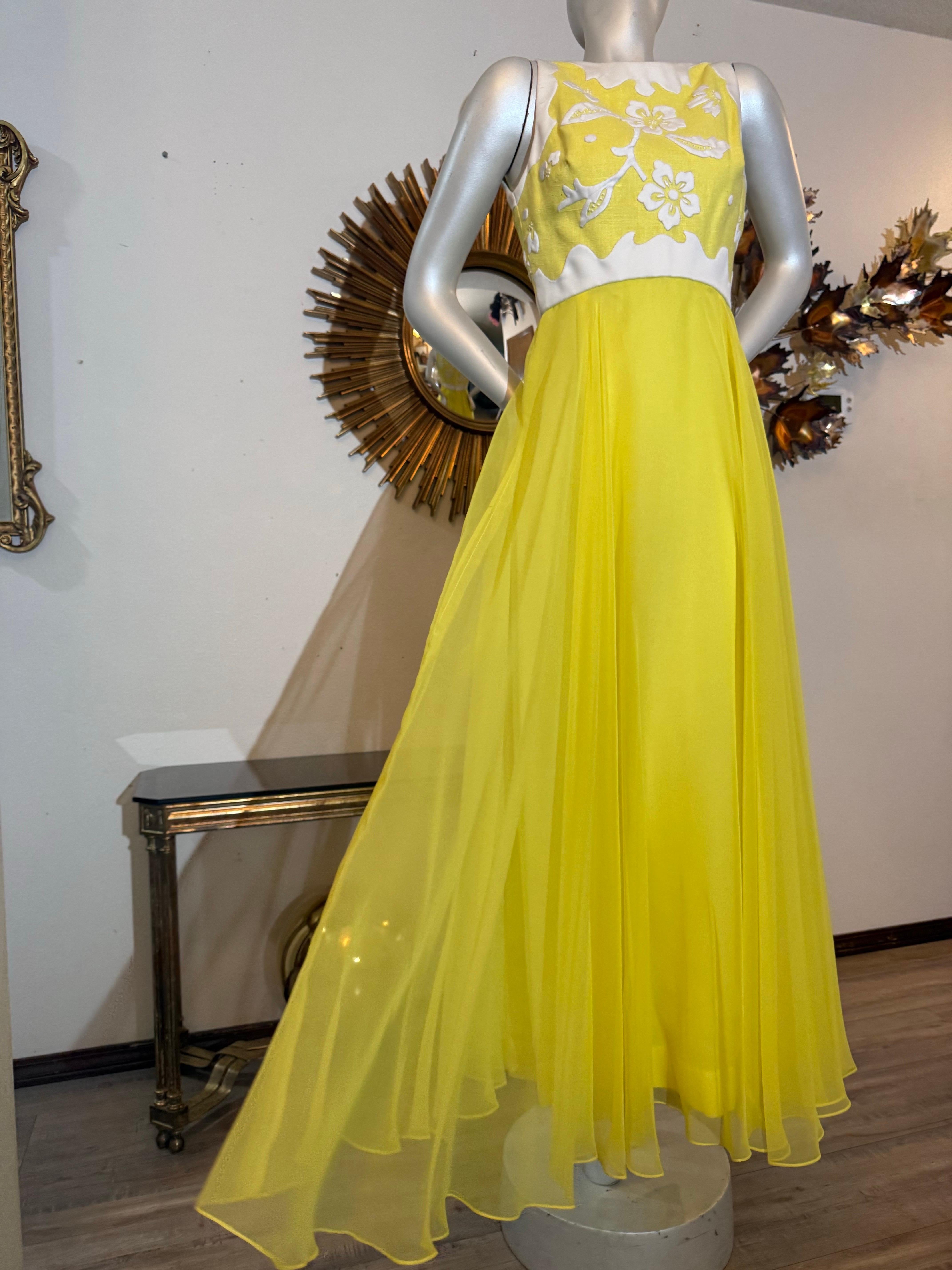 Robe longue en mousseline jaune Harmay des années 1960 avec corsage à motifs floraux blancs en Matelessé : La jupe en mousseline synthétique est ample et fluide. Fermeture à glissière au dos. Entièrement doublé. Excellent état. Taille 6. 