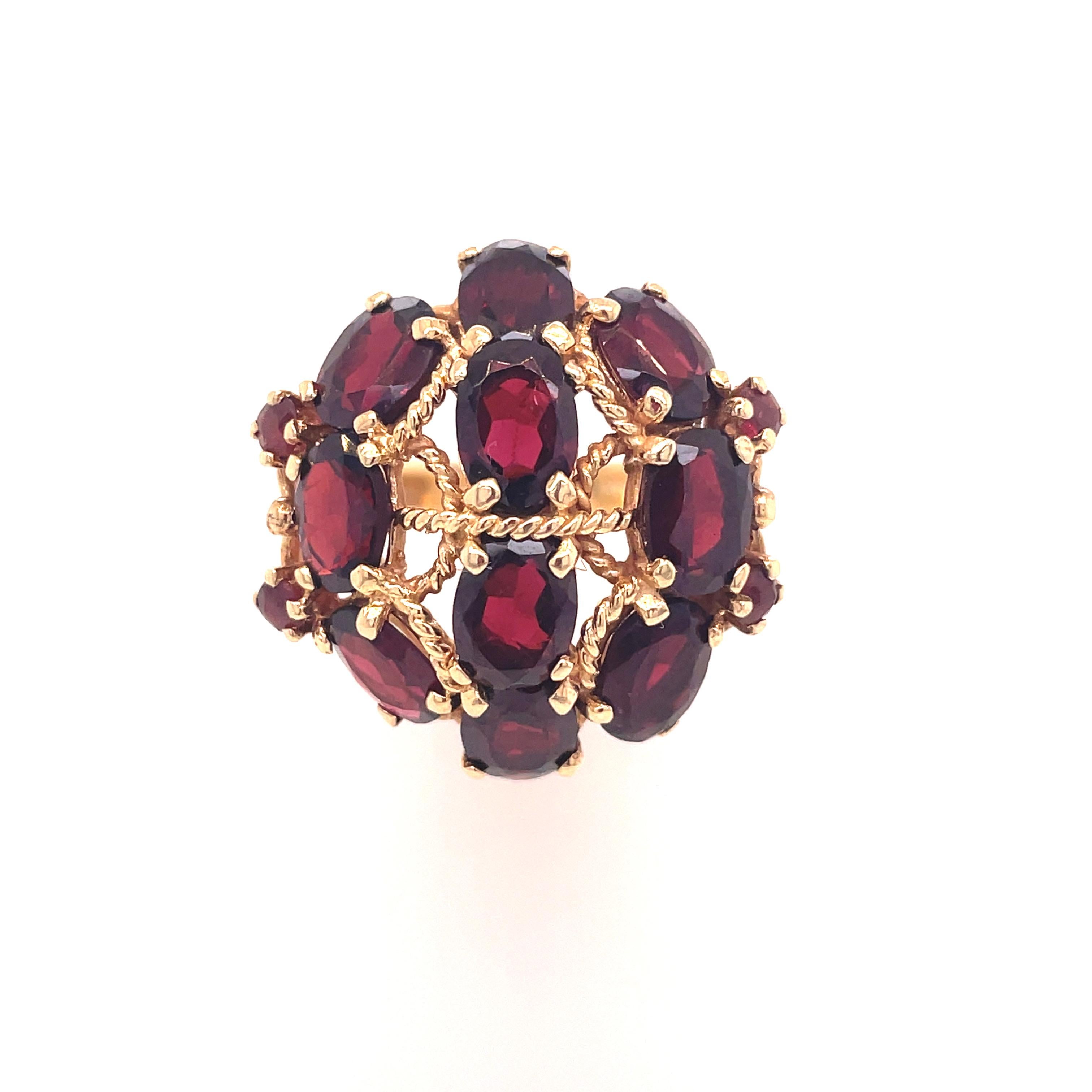 This is a stunning 14K yellow gold ring from the 1960s that features a stunning cluster of rich red garnet stones. This is a gorgeous ring that could be seen from tables away! Fourteen firey red garnet stones secured by warm golden metal twisted in