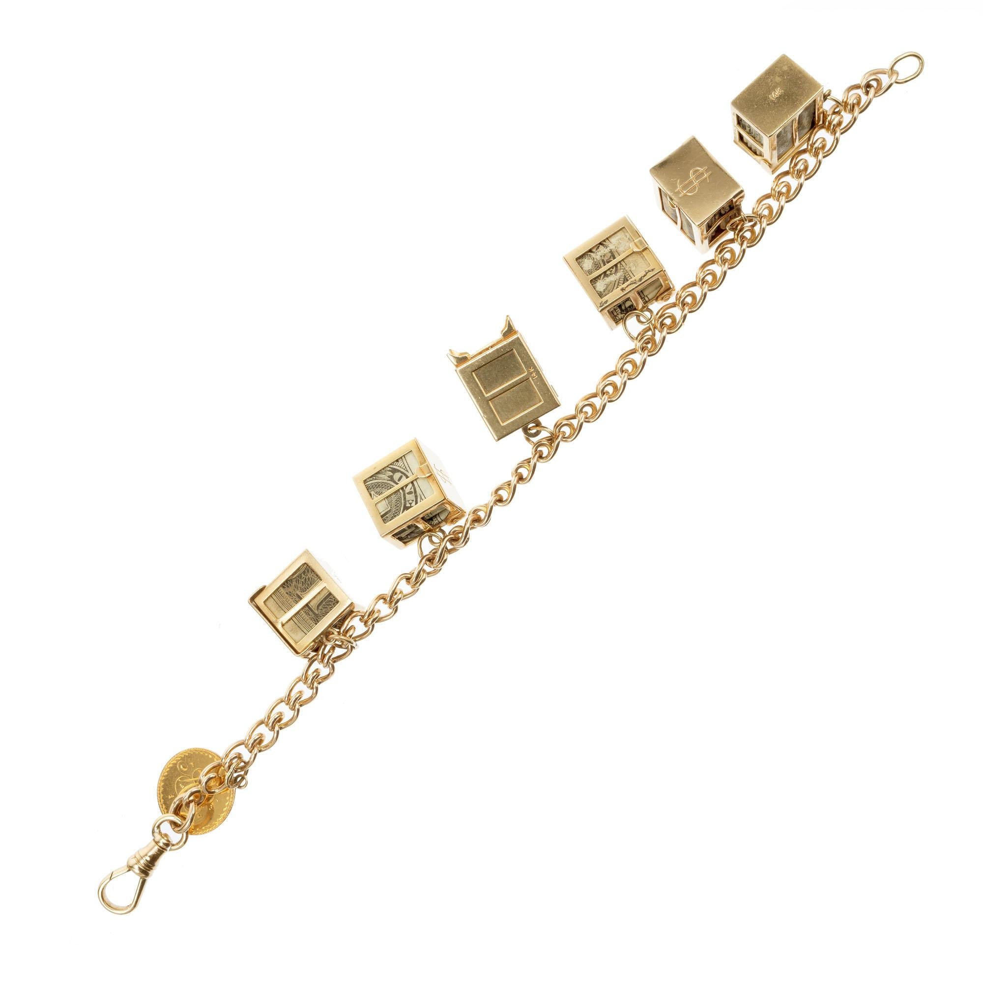 bracelet à breloques en or 14k des années 1960 sur le thème de l'argent fou. Cinq breloques argent fou, chacune avec un billet d'un dollar plié. 6 coffres-forts en or avec une pièce d'or gravée de 1852. Fabriqué à la main avec un loquet pivotant. 8