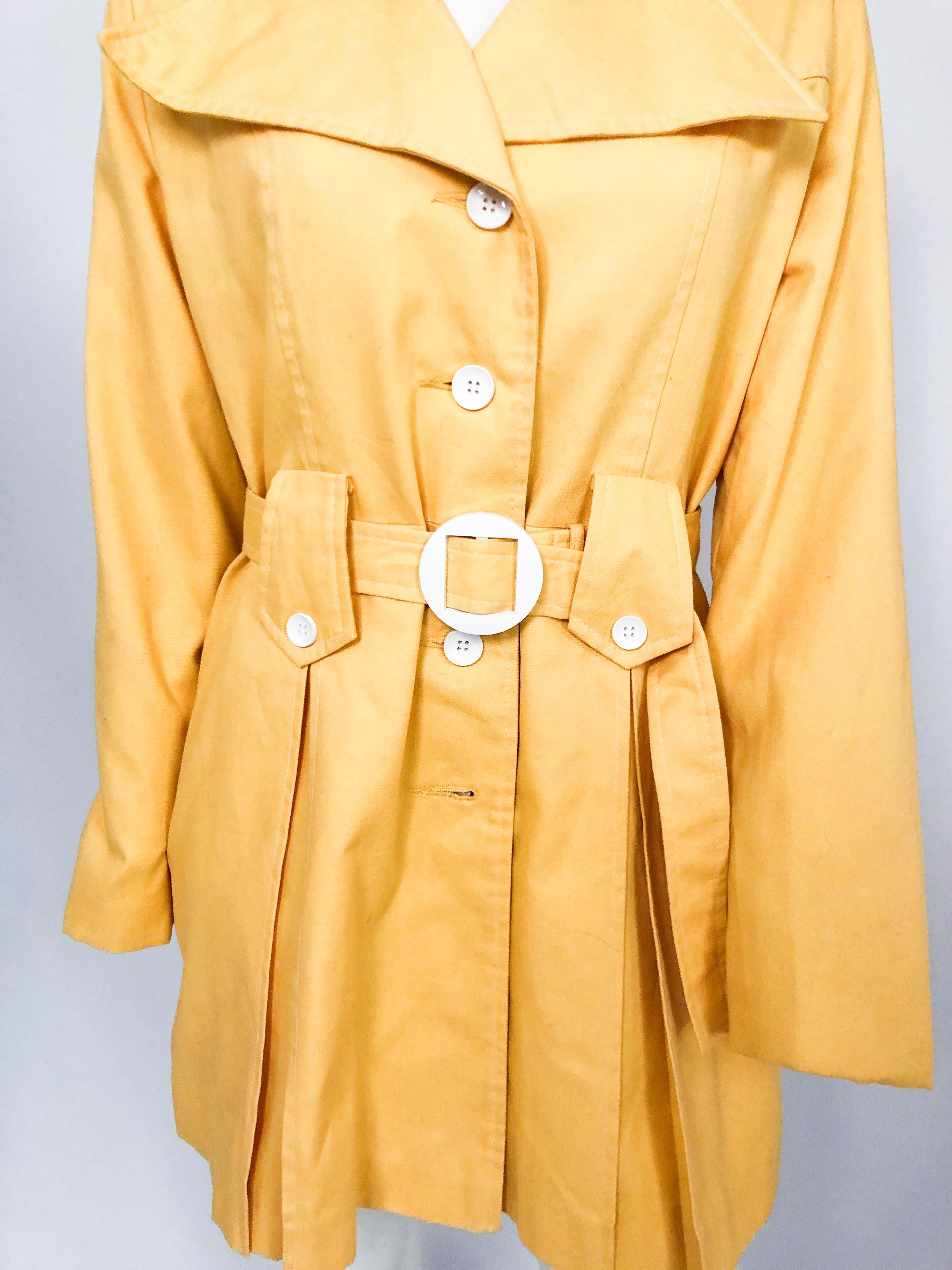 1960s Yellow mod trench jacket with enlarged collar, matching belt, flared waist, and white buttons/buckle.