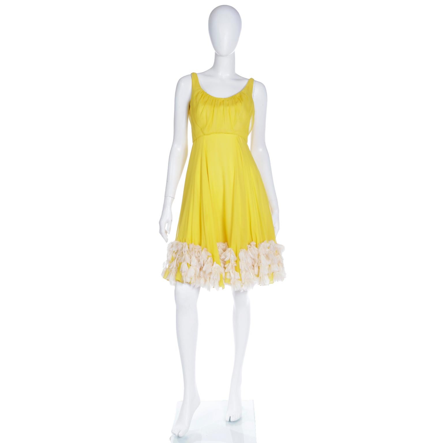 This ethereal vintage 1960's yellow silk chiffon dress has unique rows of faux feather trim around the hemline. The 
